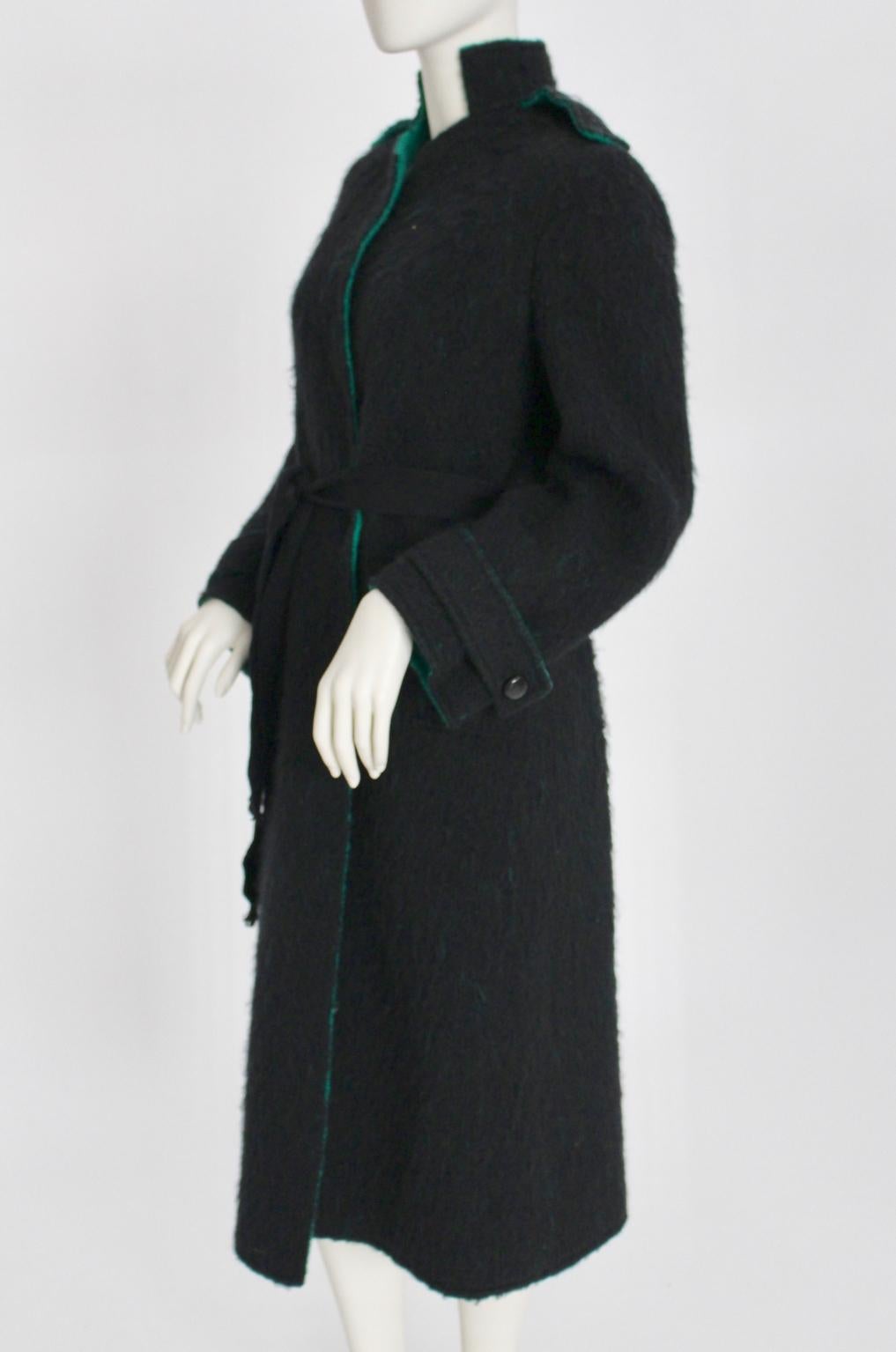 This woolen coat in the colors black and emerald green is a great vintage piece from the 1970s.
The coat features a standing collar and two side pockets.
On the sleeves and on the shoulders are one-buttoned cuffs.
The coat is belted.
Best fit for