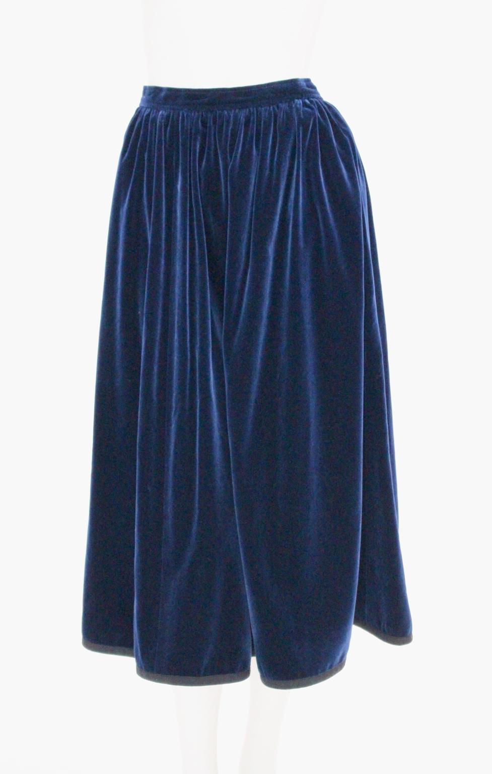 This presented skirt was designed by Yves Saint Laurent Rive Gauche and was made in France.
The blue velvet skirt shows tiny pleats on the waist and a black ribbon braid at the hem.
Zip closure and a hook for closing the skirt.
A nice side pocket on