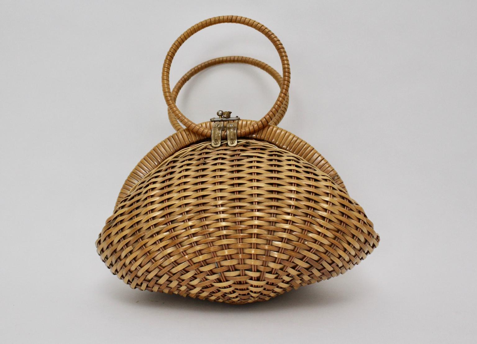 Lovely rattan handbag riviera style from the 1950s . 
Closing with a metal closure hook. 
The handbag features 2 round handles.
Inside lined with plastic with a side pocket.
The original condition is very good with minor signs of age and use.