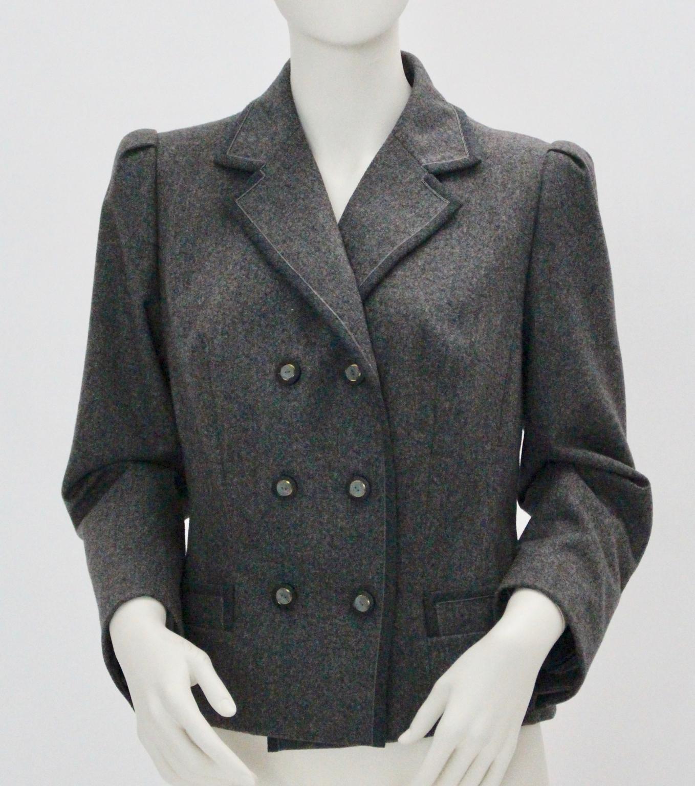 Grey woolen straight cut double-breasted Jacket with 6 buttons closure and two side pockets.
A dark-grey piping is running along the hem.
The ruffles at the shoulders are a nice feminine detail and give this jacket a 1940s touch.
Labelled inside: W.