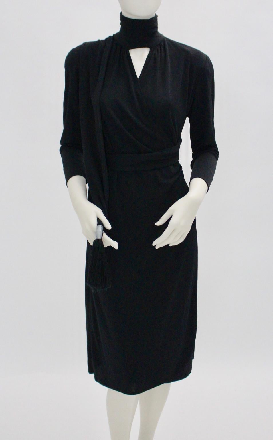 The black evening dress was designed and made in Italy in the 1970s.
This evening dress features many nice details:
3 buttons at the collar
Shoulder pads
Long sleeves with button detail

This wrap dress has buttons inside - adjustable - for the best