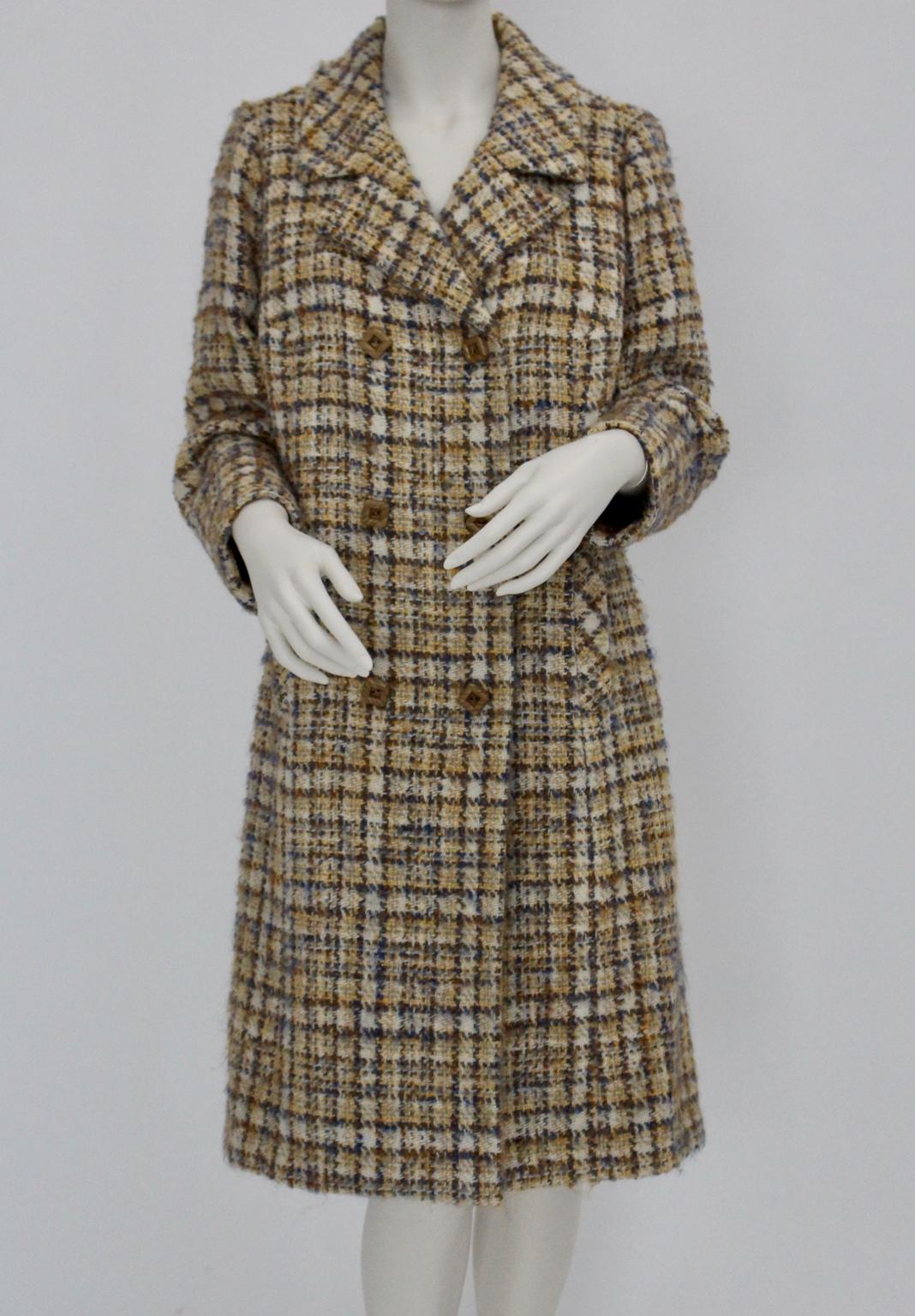 This coat by Herbert Schill was made of tweed boucle fabric in the charming colors wool white, blue and cappuccino.
The coat features a double- breasted button closure with cappuccino colored square buttons and two side pockets.
The tweed fabric