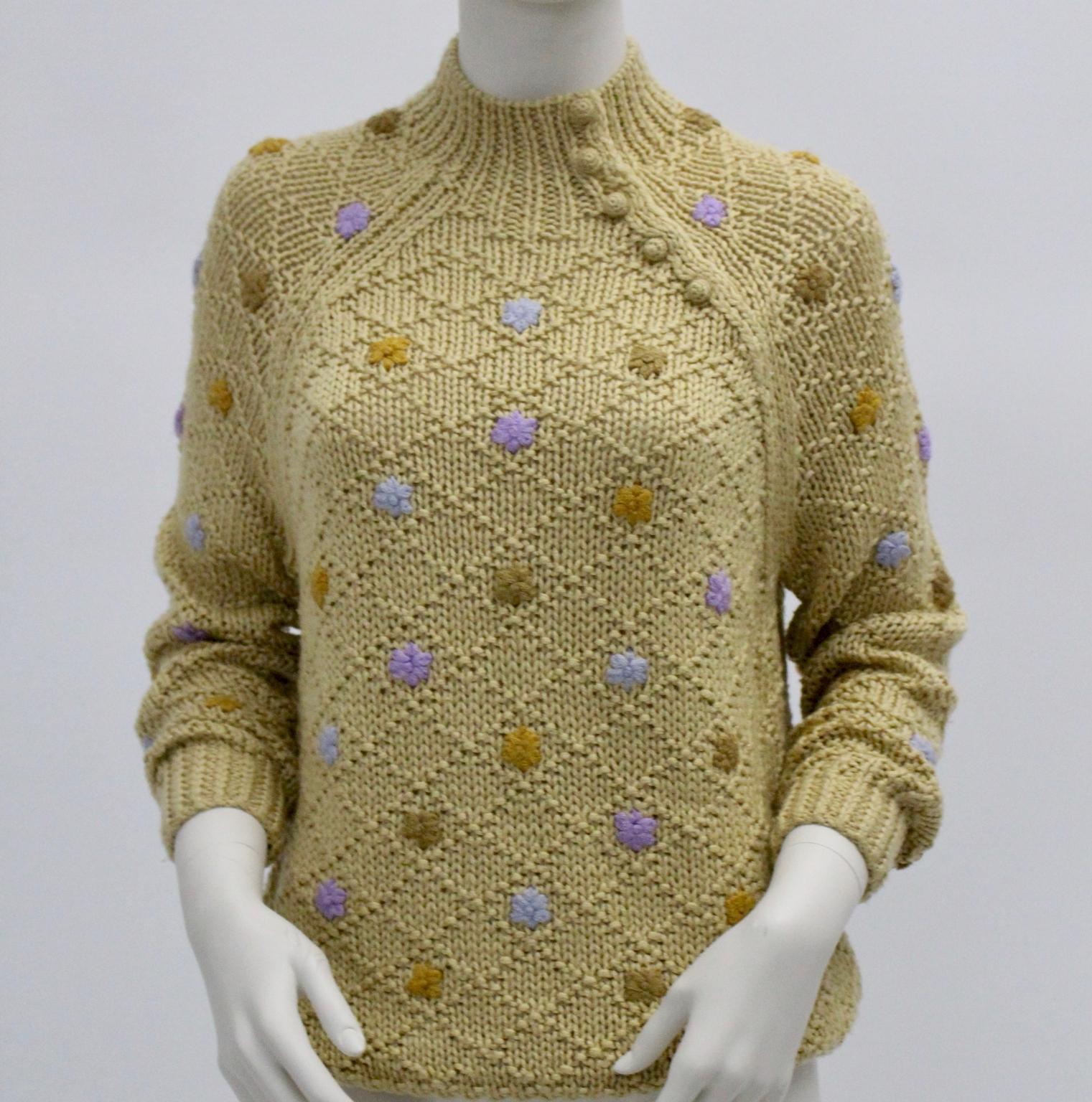 This knitwear sweater by Oscar de la Renta Sport was made of brown knit with rhombs and decorated with stitched flowers in the colors brown, lilac and light-blue.
At the collar are 5 buttons for closure.
Also shows this sweater raglan sleeves.
The