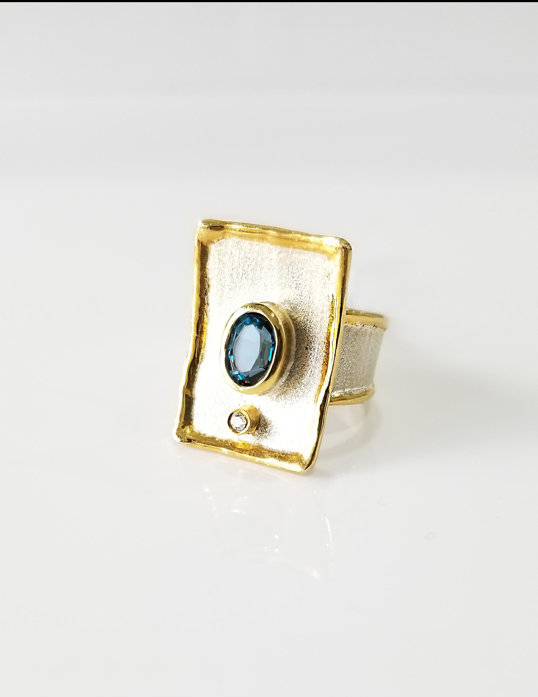 
Yianni Creations 100% Handmade Ring from Fine Silver with a layover of 24 Karat Yellow Gold features 1.60 Carat London Blue Topaz accompanied by 0.03 Carat Diamond all complimented by unique techniques of craftsmanship - brushed texture and