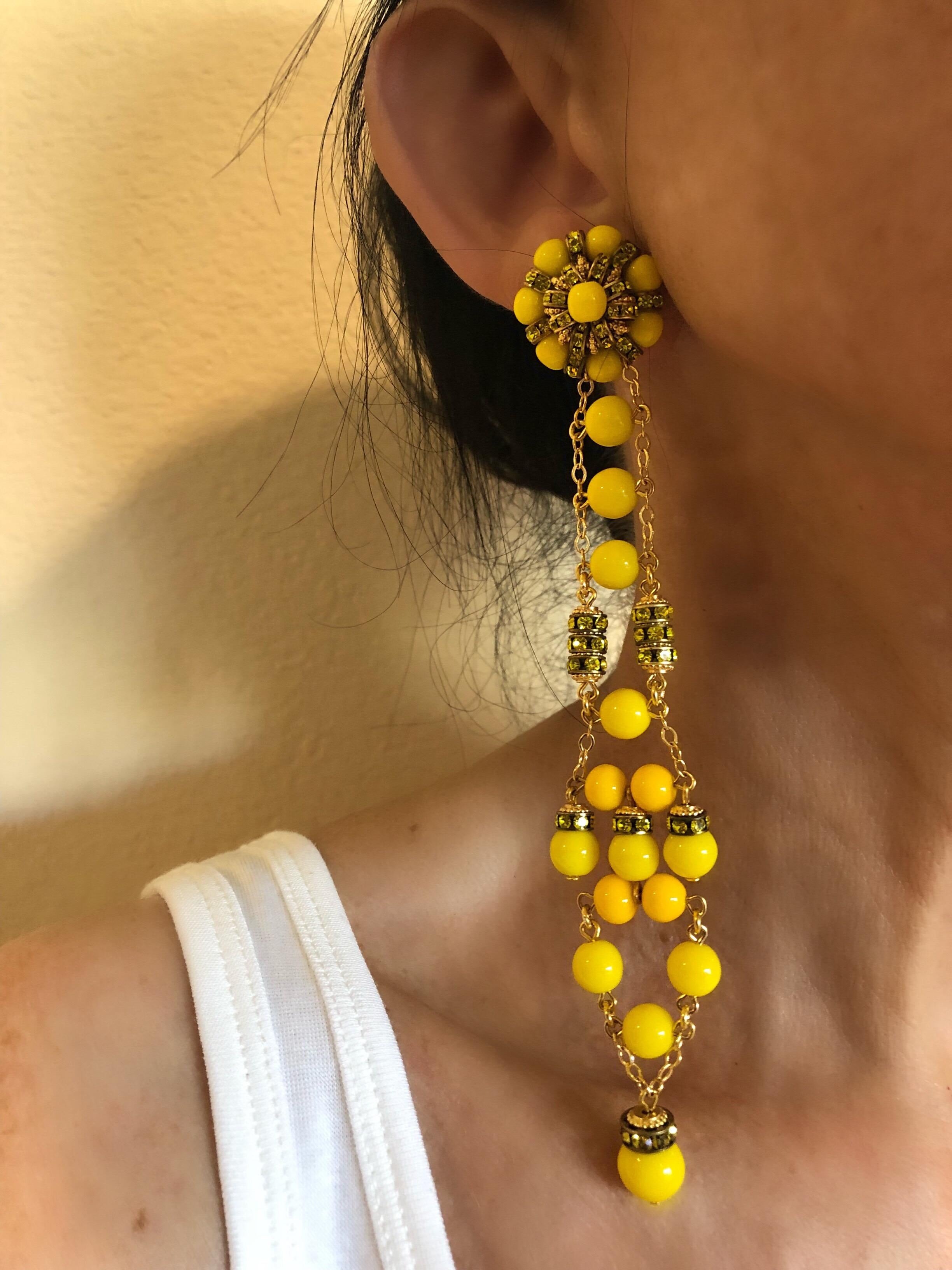 Can you say DRAMA? These dramatic French statement earrings were created by the Parisian house of Francoise Montague in Paris. Comprised of gold-tone chain the long linear earrings feature vintage yellow glass beads and yellow rondelle beads. The