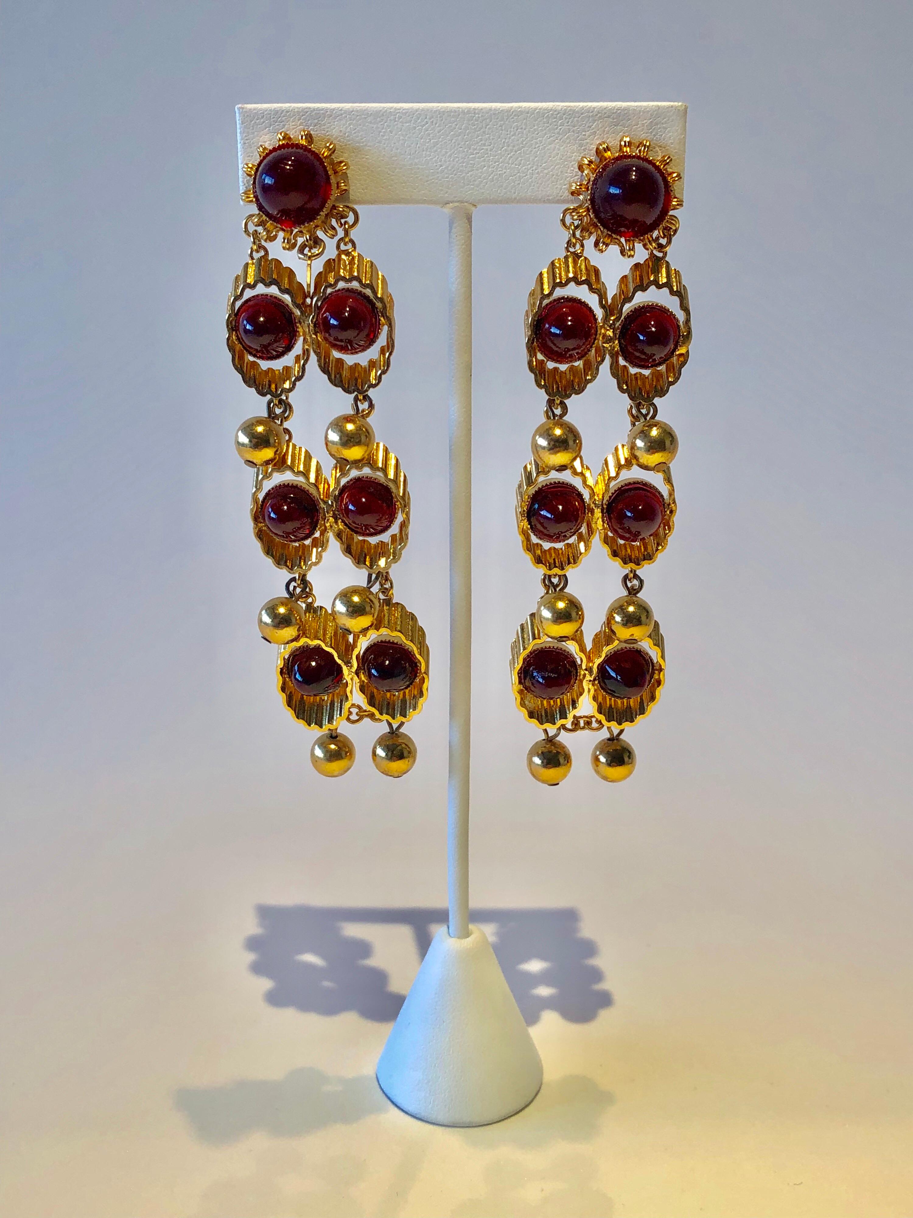 A wonderful mid-century modern example of 1960's modern earrings - The architectural earrings are comprised out of gold-tone metal waved cones which are staggered and articulated - they are accented by red glass cabochons and gilt dangling balls. In