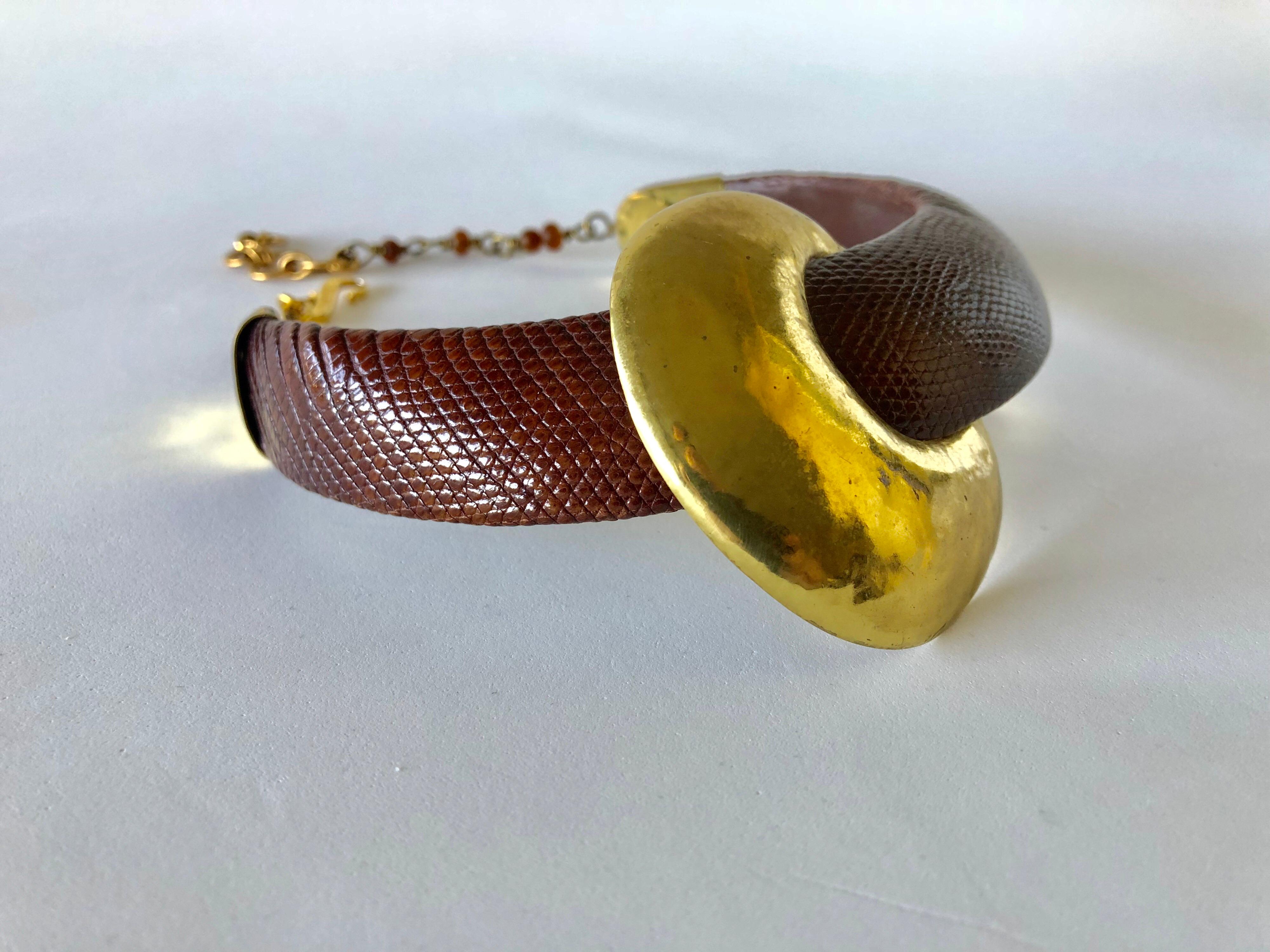 Chic, sleek and contemporary vintage statement necklace comprised of brown snake-skin accented by a large hammered gold brass modernist adornment. The scarce and unique necklace was designed in the 1980s for Fabrice Paris - signed on the back of the