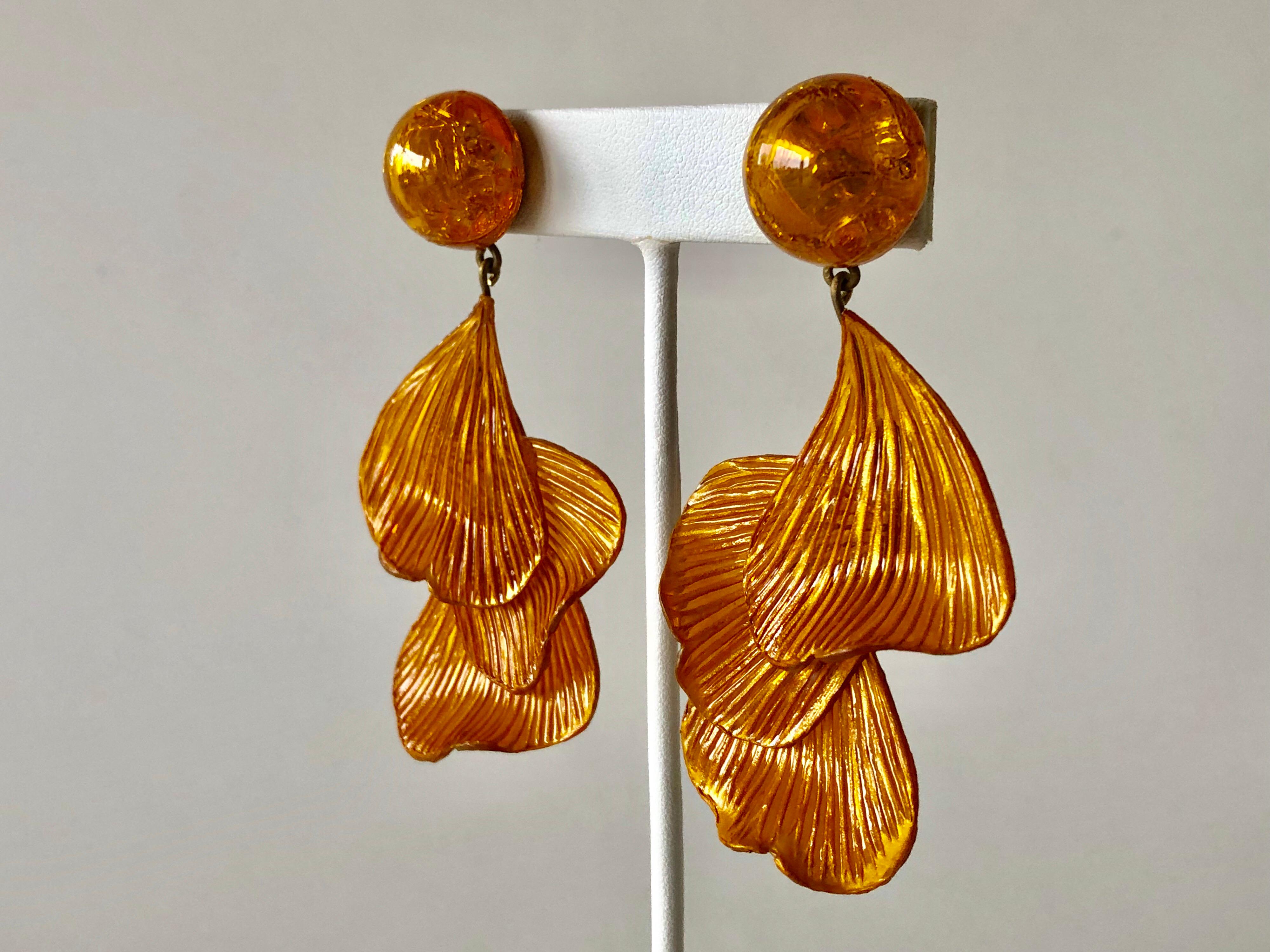 Light and easy to wear, these handmade artisanal pierced earrings were made in Paris by Cilea. The lightweight clip-on earrings feature molded wave segments of enameline (enamel and resin composite) in orange, almost resembling whimsical fish tails.