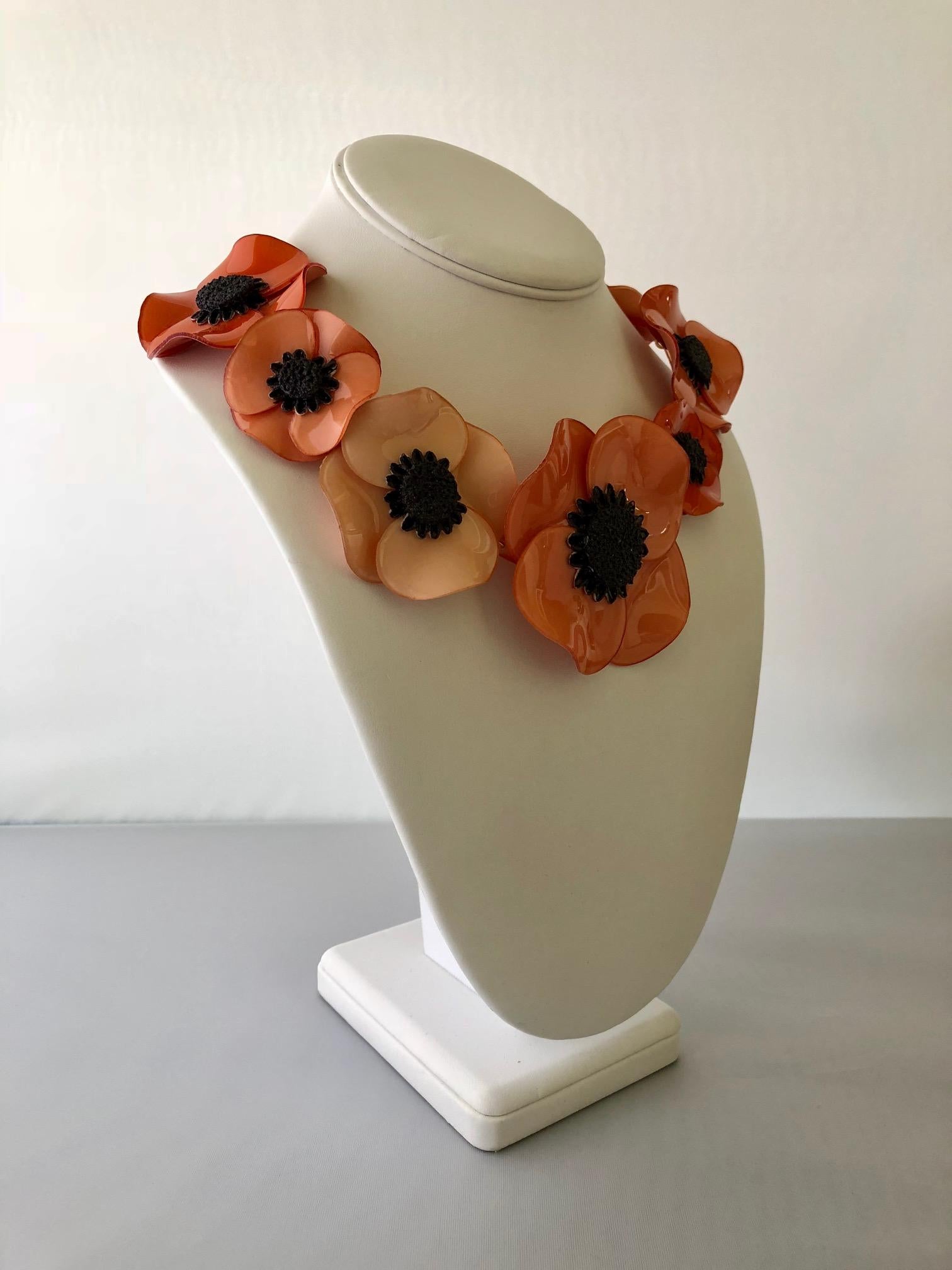 Light and easy to wear, this handmade adjustable artisanal necklace was made in Paris by Cilea.  The necklace features seven architectural enameline (enamel and resin composite) poppy flowers in different shades of pink and coral. The poppies are
