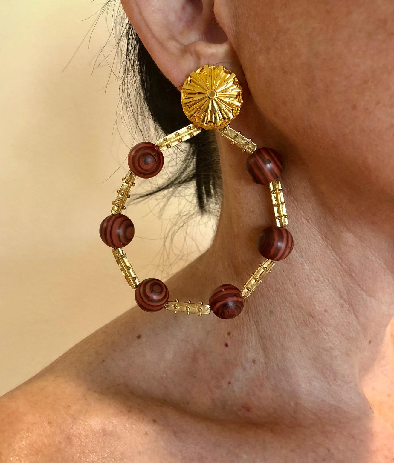 Vintage oversized clip-on hoop earrings by the House of de Lillo. The round statement clip-on statement earrings are comprised of long gilt metal beads which are accented by six genuine exotic patinaed bamboo round beads. They are lightweight and
