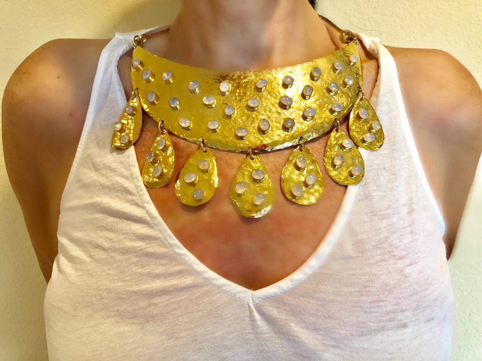  Statement necklace hand constructed by William de Lillo, comprised of hammered 18k gold electroplated brass adorned by German crystal opal cabochons. The sleek and chic necklace has a forceful mid-century modern design that is stylish and current,