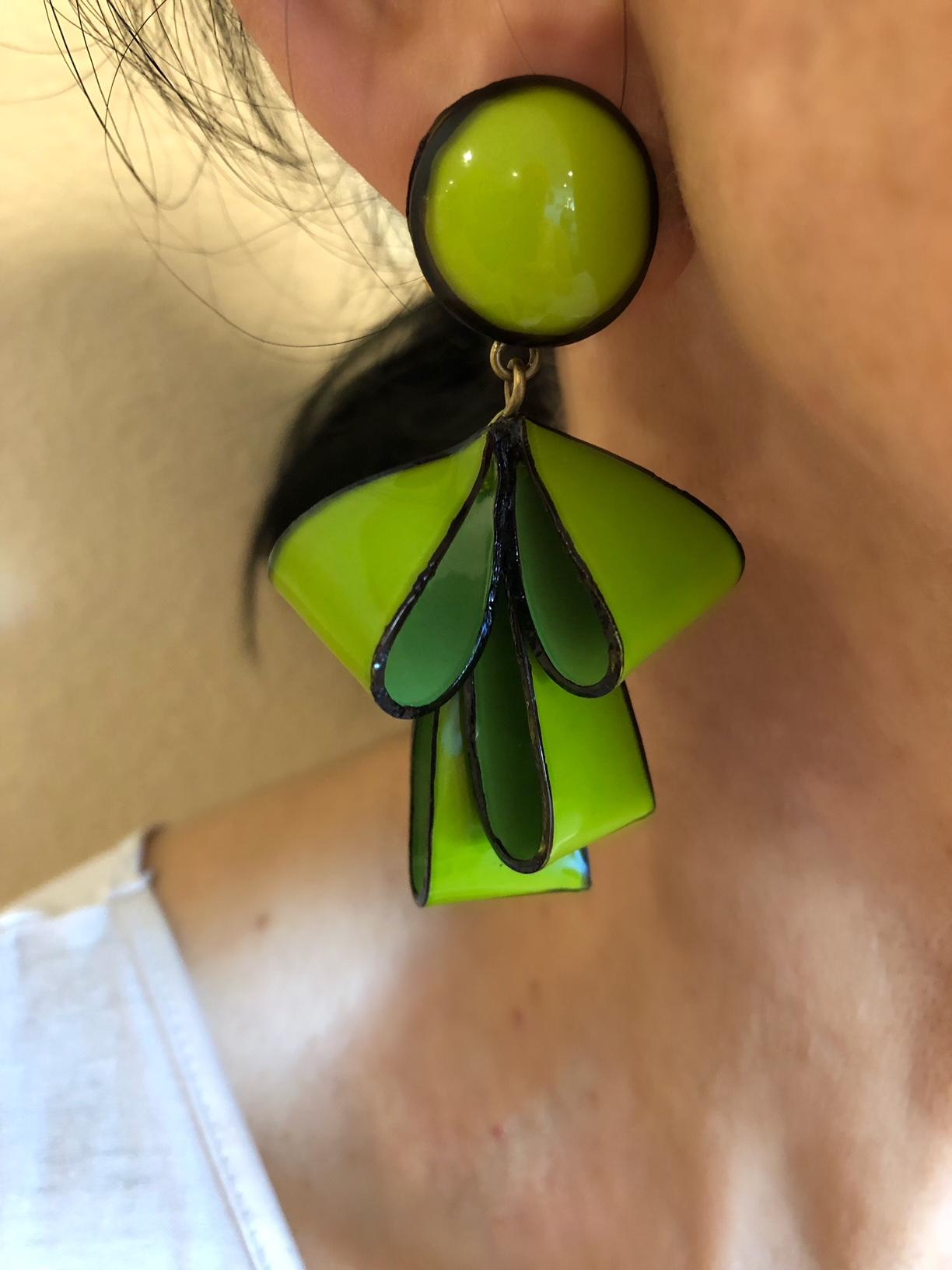 Light and easy to wear, these handmade artisanal clip-on earrings were made in Paris by Cilea. The lightweight earrings feature  folded ribbon-like segments, comprised out of enamel and resin. The earrings three-dimensional design features a bright