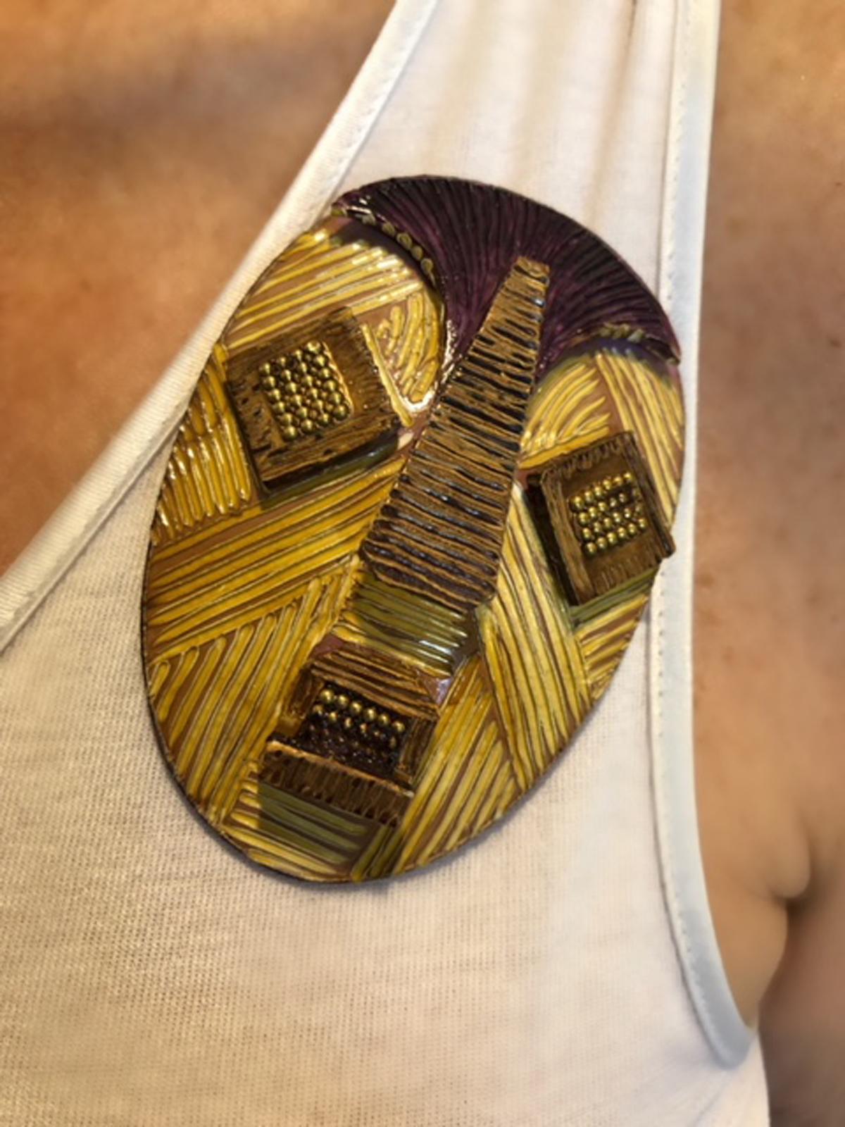 Light and easy to wear, this handmade artisanal pin was made in Paris by Cilea. The lightweight pin features a tribal African/Tiki mask, comprised out of enamel and resin composite. The pins three-dimensional oversized body features bright colors, a