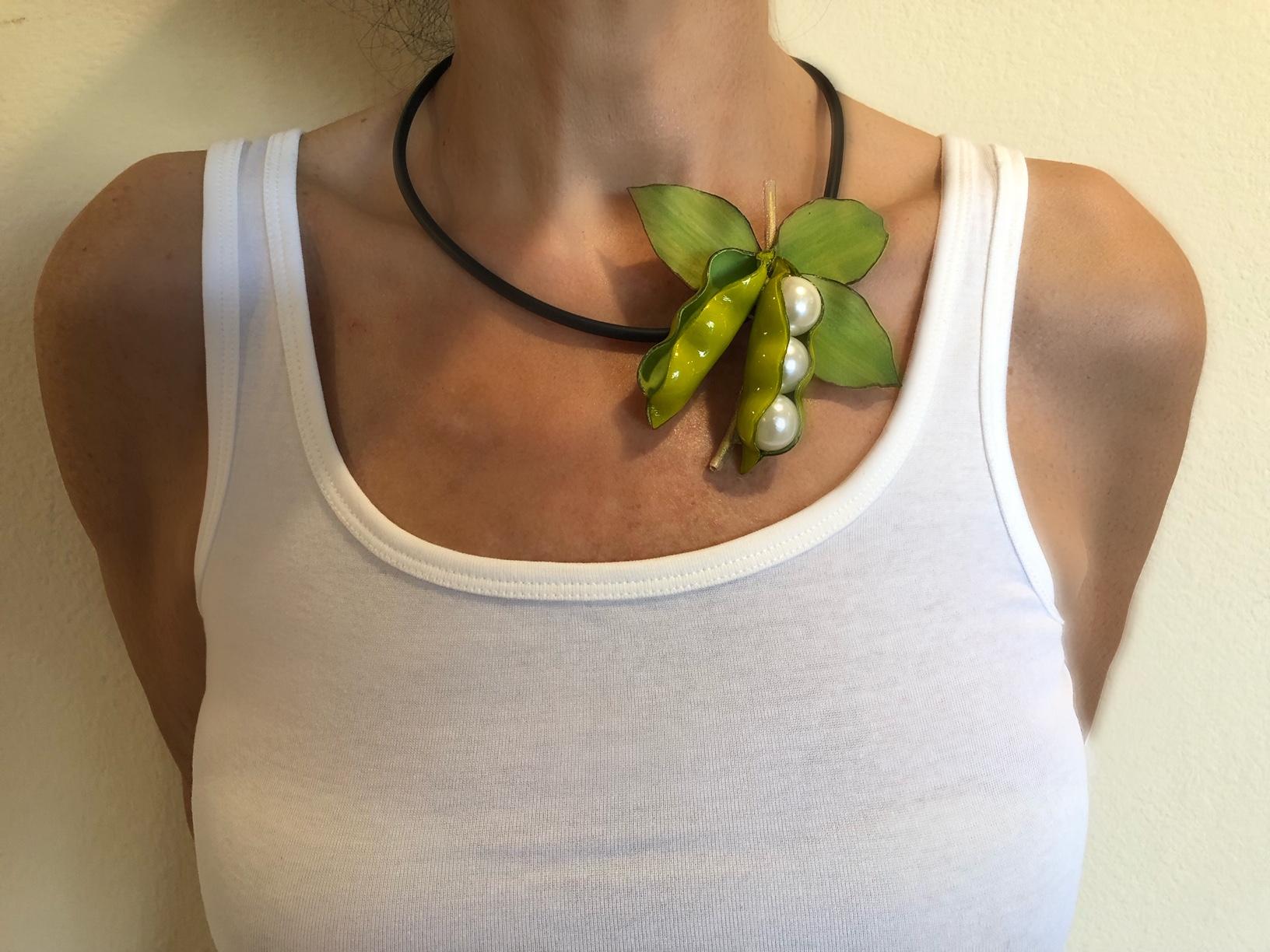 Light and easy to wear, this handmade artisanal necklace/pin was made in Paris by Cilea. The lightweight pin features two pea-pods. The pins three-dimensional oversized figure features bright colors, hand manipulated details and creamy faux pearls.