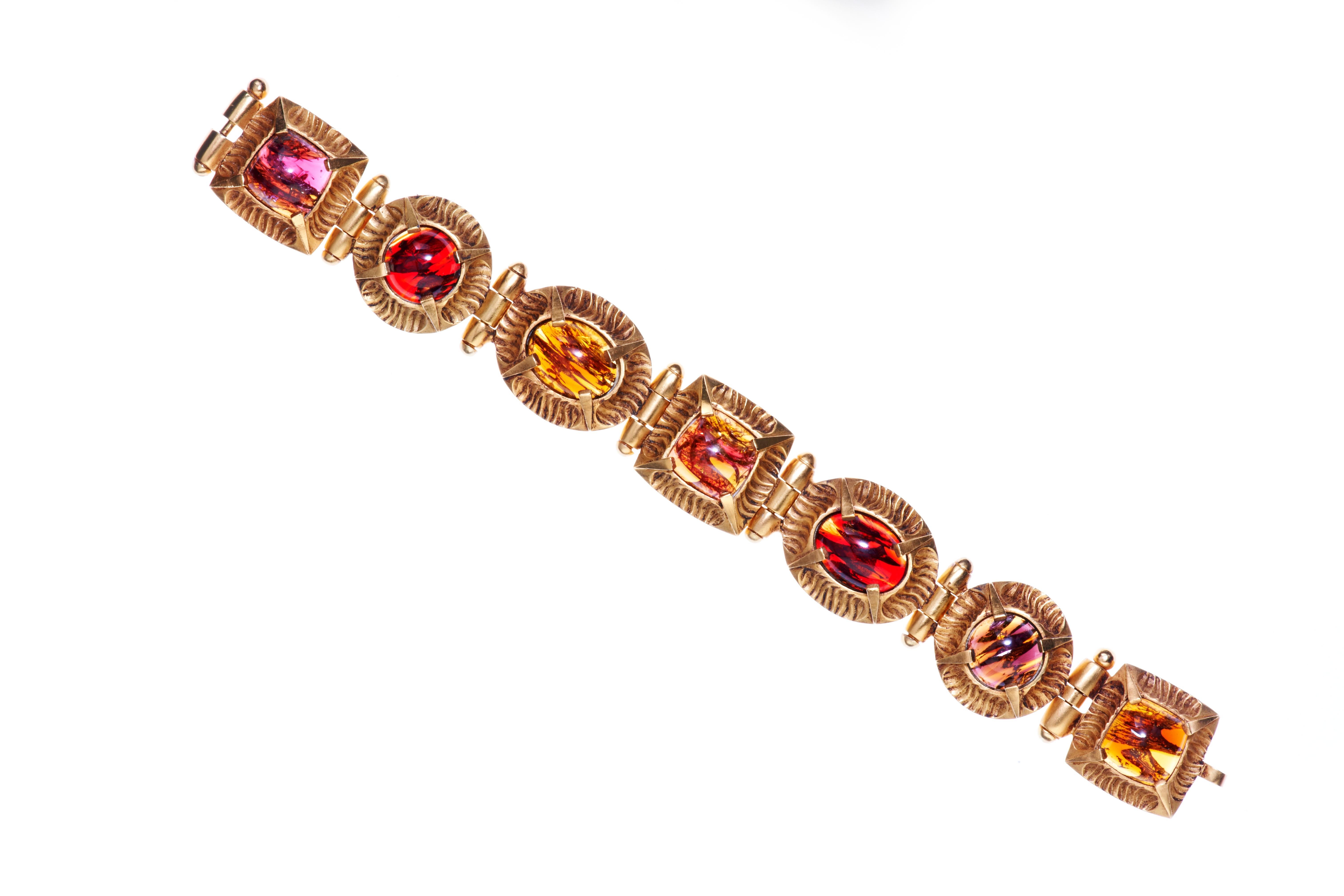 The beauty in the geometry highlights the exquisite handmade glass cabochons that drape around the wrist perfectly.  The bracelet is finished with 24 carat gold with cabochons in ruby and amber or rhodium with aqua blue, emerald and royal blue. An