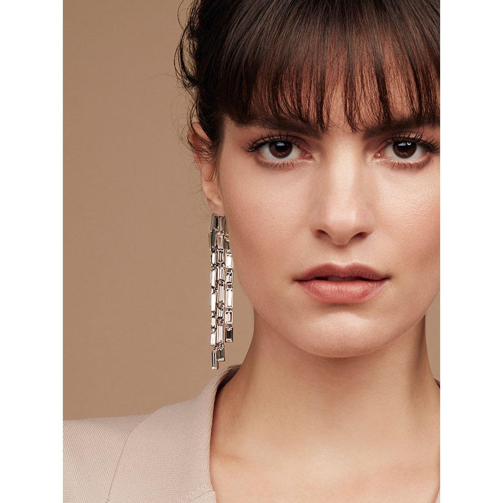 These flexible tassels of baguette cut Swarovski ® crystal stones catch the light accentuating movement. These Caddis long earrings plunge like trails of water falling from a waterfall, shimmering as light trails downwards.

This collection evokes