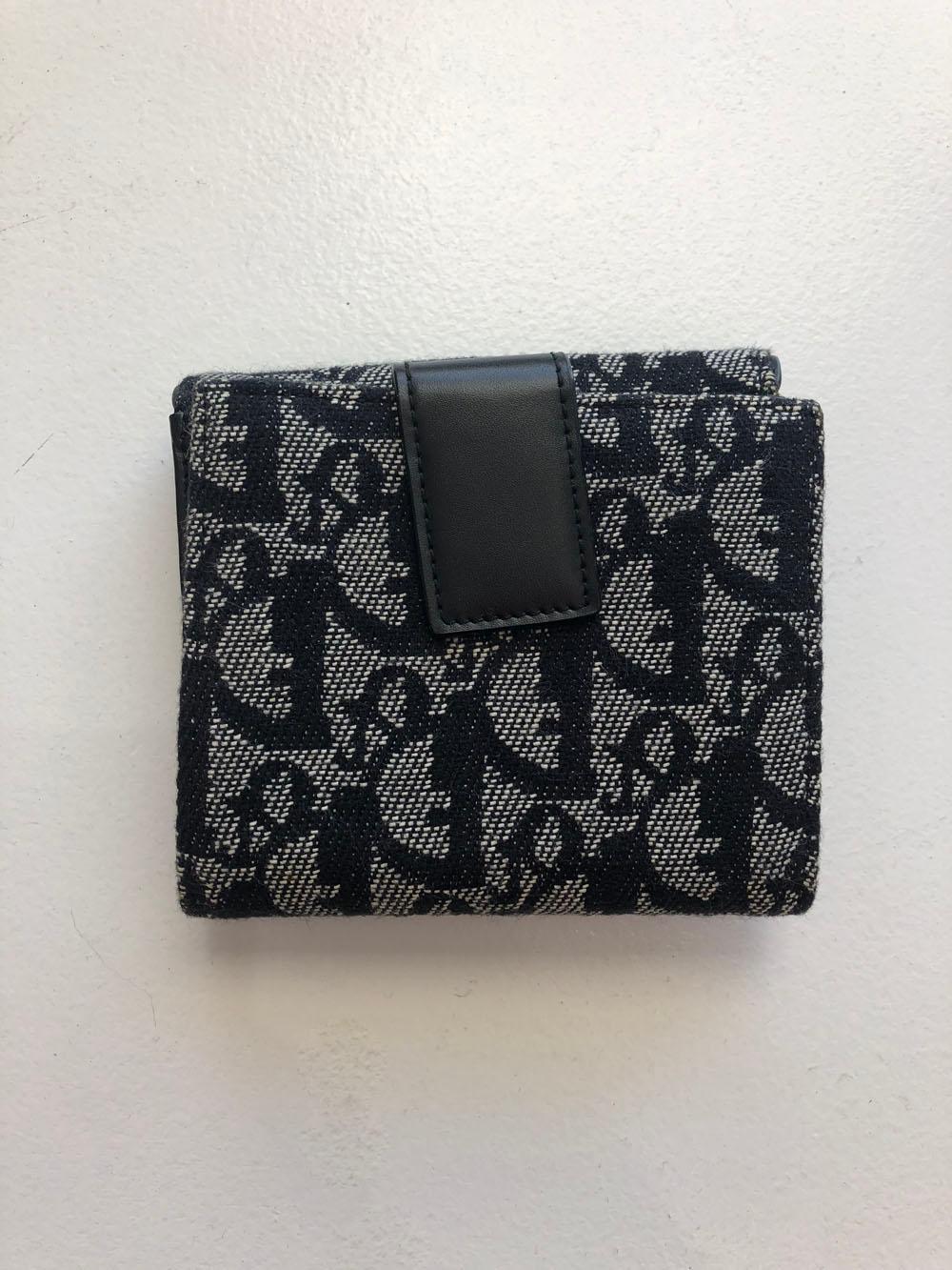 Christian Dior navy monogram bifold wallet with black leather inside and snap closure. This is a vintage piece, but in unused condition. Front compartment has two slip compartments to hold change, while the back flap folds out to reveal 8 card slots