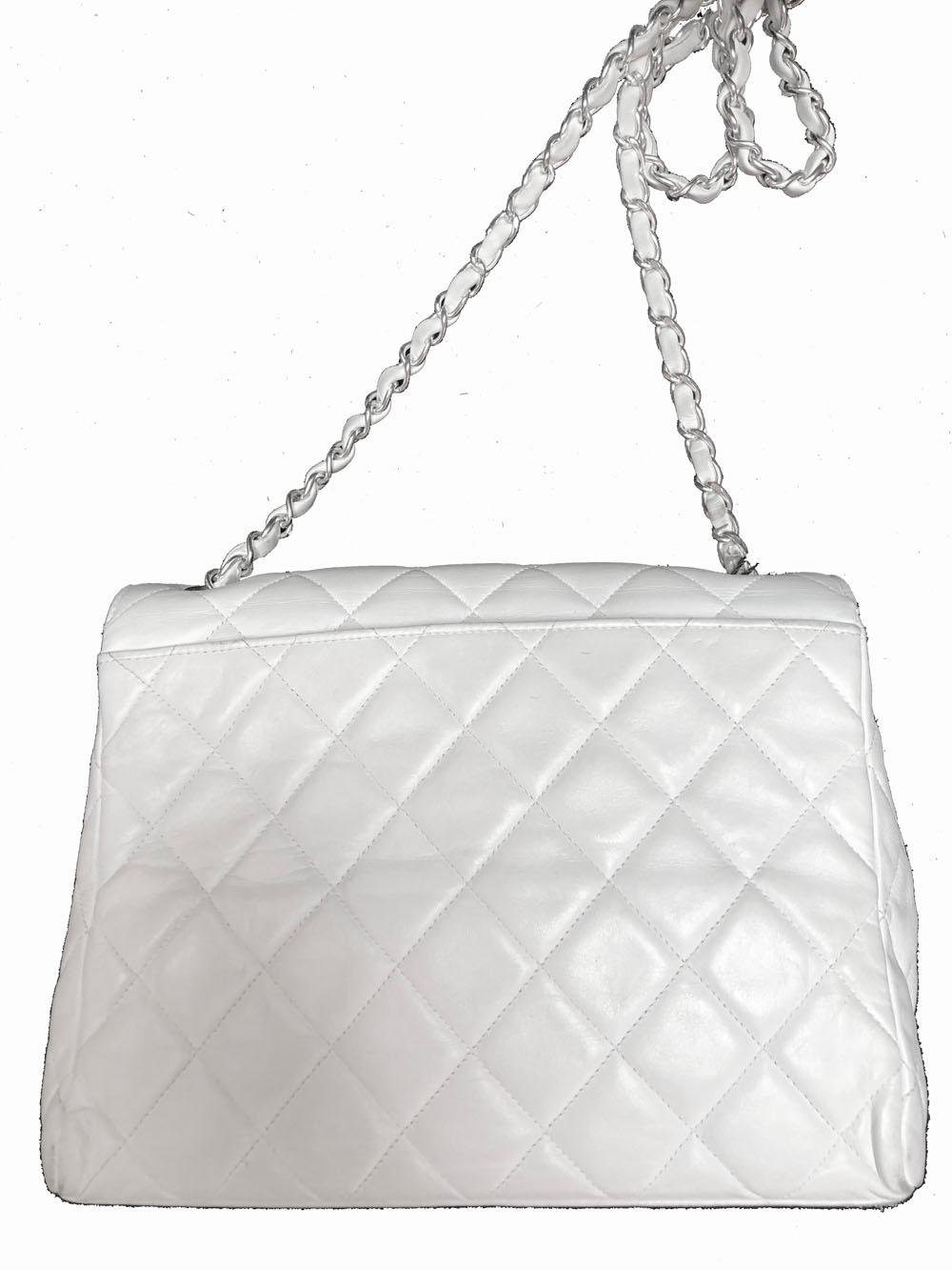 Chanel flap bag from the late 90s. Quilted white leather with silver hardware. Chain strap. Turnlock closure. CC logo embroidered on inside flap. One internal slide pocket, one internal zip pocket. One slide pocket on back. Some discoloration on
