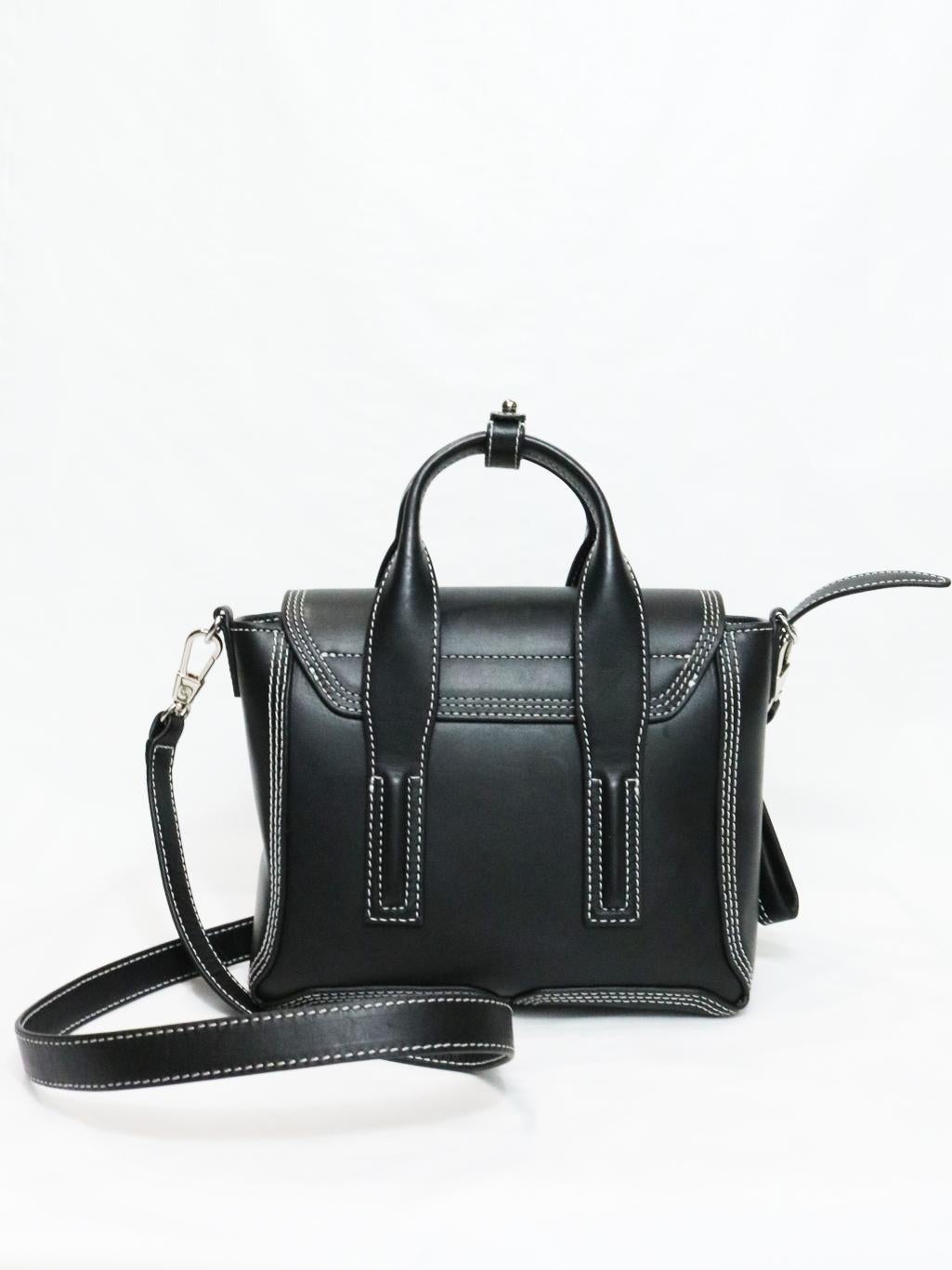 Pashli Mini Satchel black leather, is a small but powerful iconic Philip Lim bag sure to become a staple in your bag rotation. Featuring detachable shoulder strap, double top rolled handles, flap top with push lock closure, exterior zipper gussets