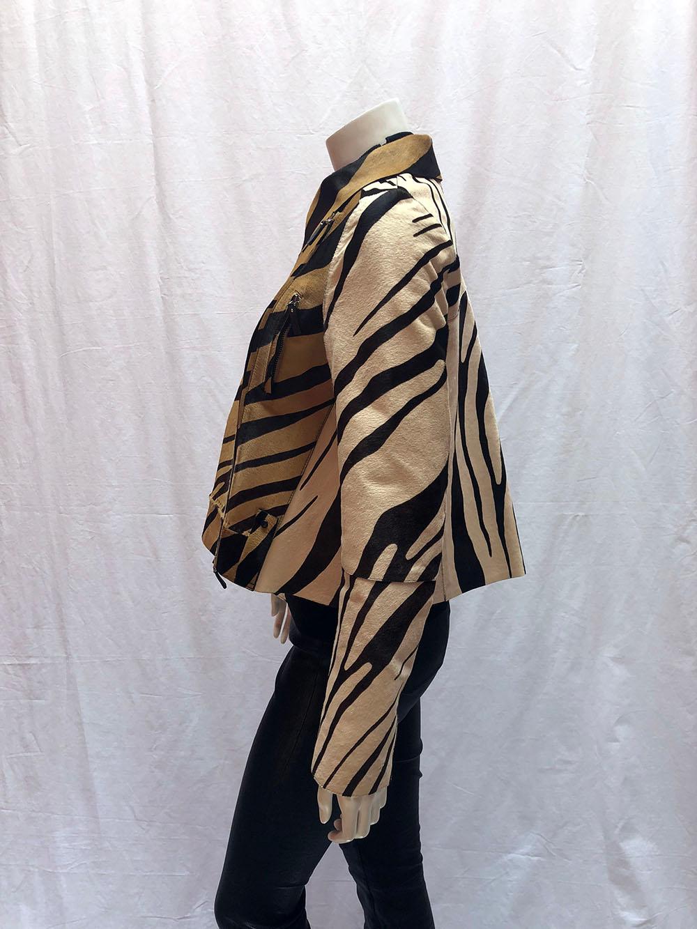 Giraffe print pony hair, moto-style swing jacket by Roberto Cavalli with black leather lining. 

Colors: camel, black, brown, and cream. Asymmetrical side zip with front snap closure pocket. Dual chest zippered pockets. Gathered backside with a