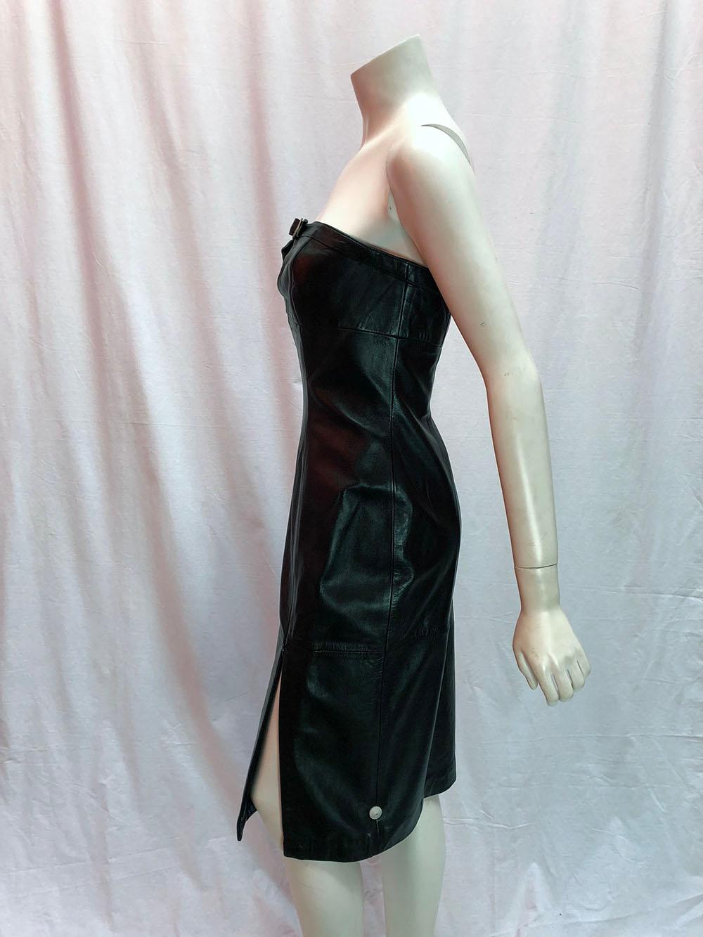 Thierry Mugler Vintage Black Leather Buckle Dress
Vintage strapless leather Thierry Mugler night out dress. Features silver buckle above the bust and a deep side slit which can be zipped up or down to reveal more or less leg. Size 42. 

Est. Retail: