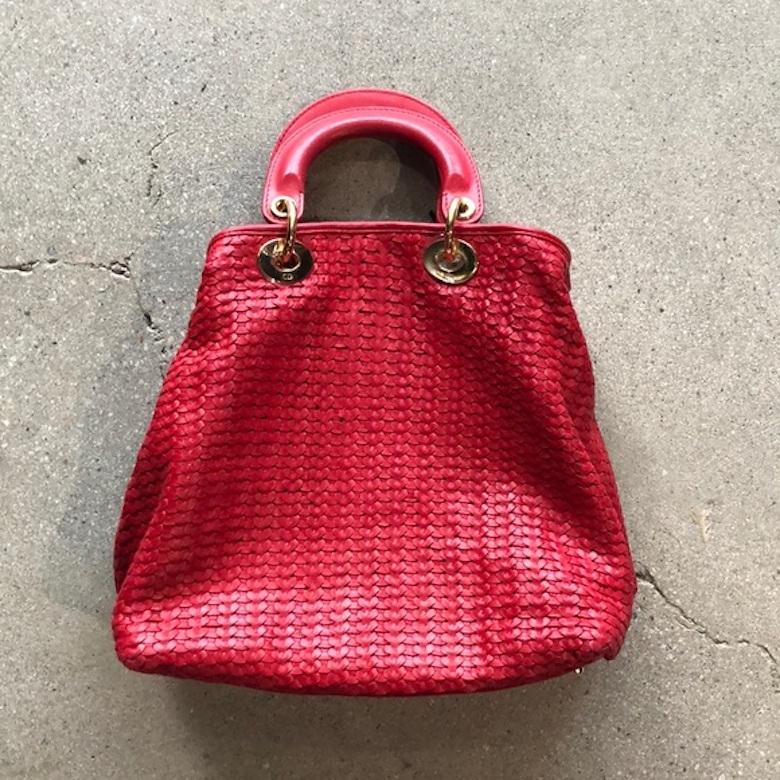 Vintage Dior Lady Bag in red woven leather. Style is comparable to that of today’s Dior Lady Bag. Red leather with gold tone hardware. Minor markings to leather on handles and on the bottom. Leather exterior is overall, in very good condition.