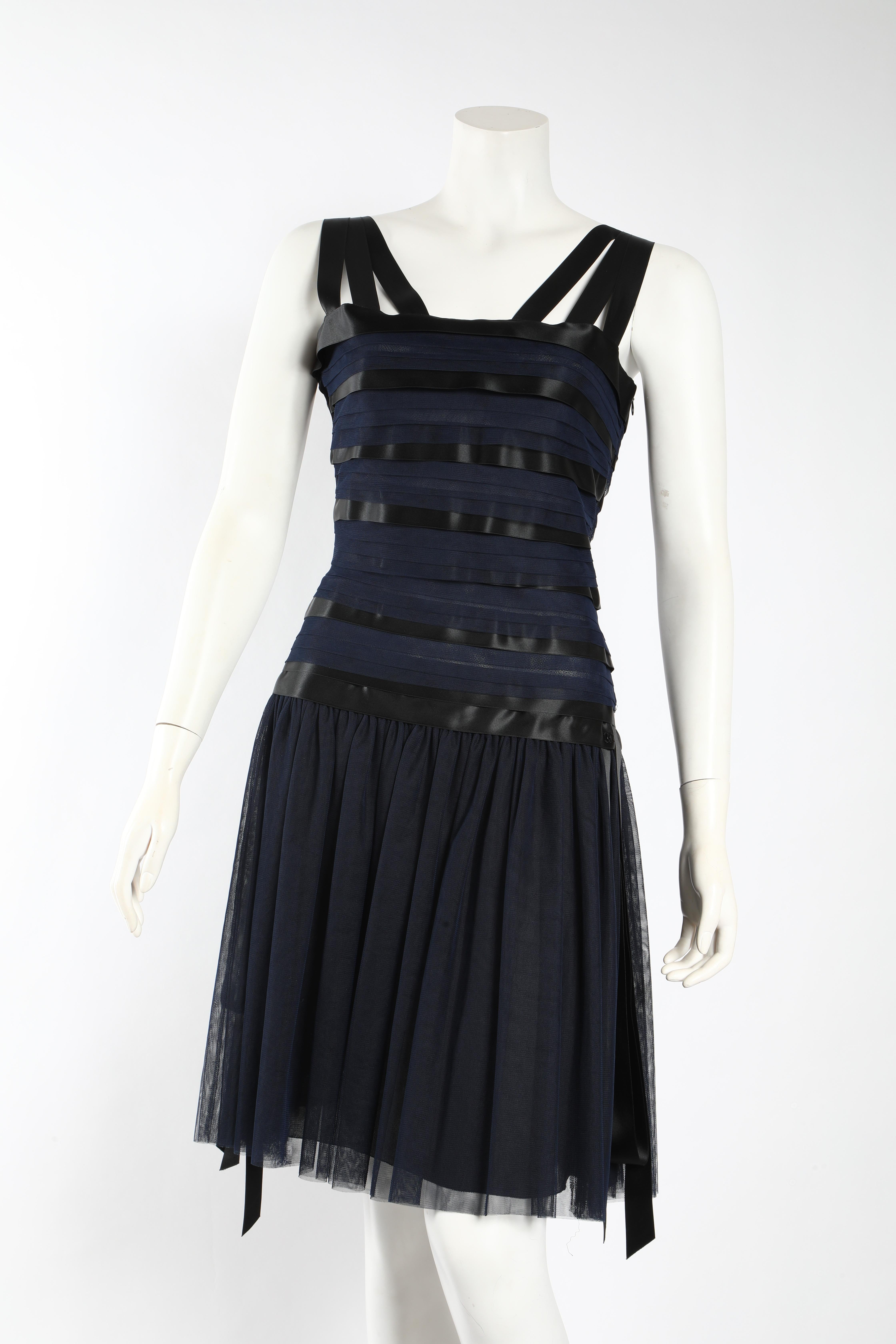 This gorgeous navy and black and ribbon Chanel runway dress is one of a kind. 
Gorgeously classic, but a show stopper.  
CHANEL 06A Runway Black silk ribboned dress with a square neckline and ribbon straps. The silhouette is a drop waist -  slim and