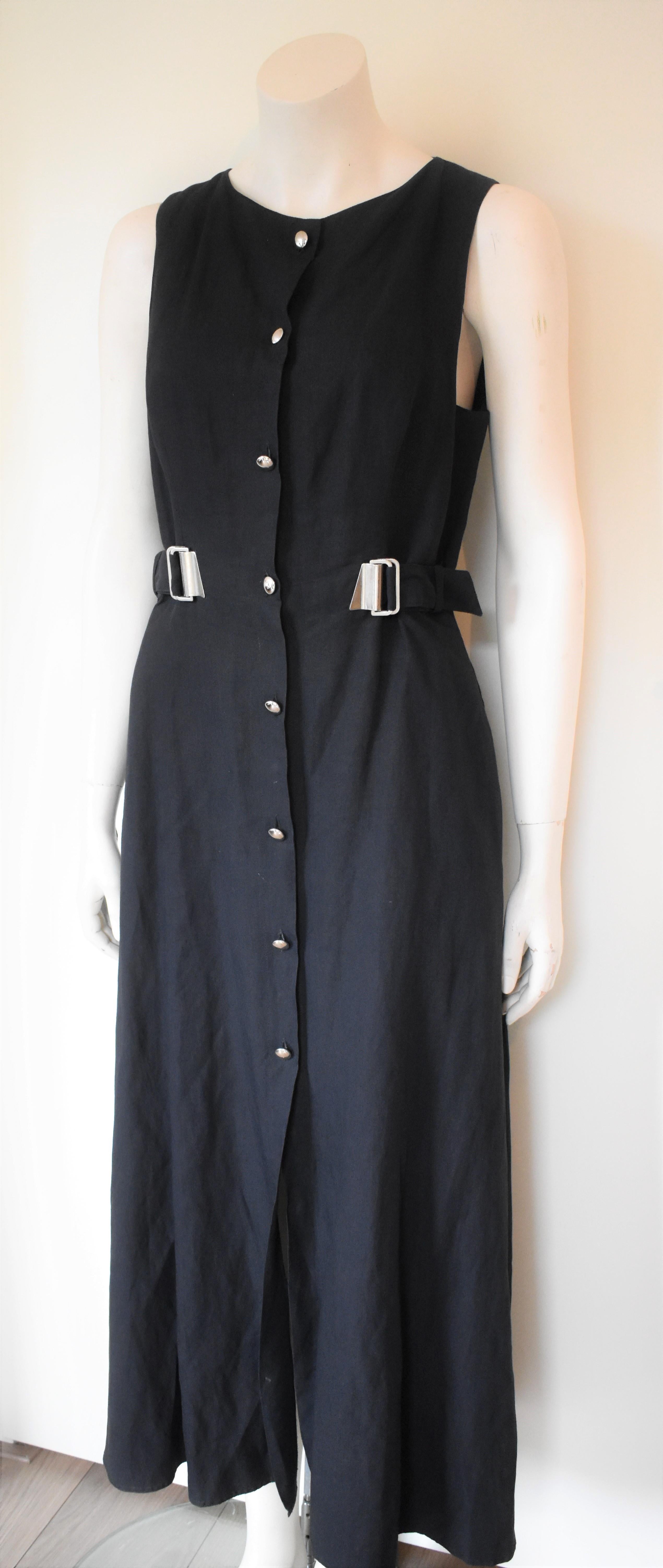 Long black cotton dress by Claude Montana, circa 1990. The dress has, in addition to the silver buttons, secret push buttons to secure it is perfectly closed. The two small buckles can be used to tighten up and accent the waist. Before shipping, the