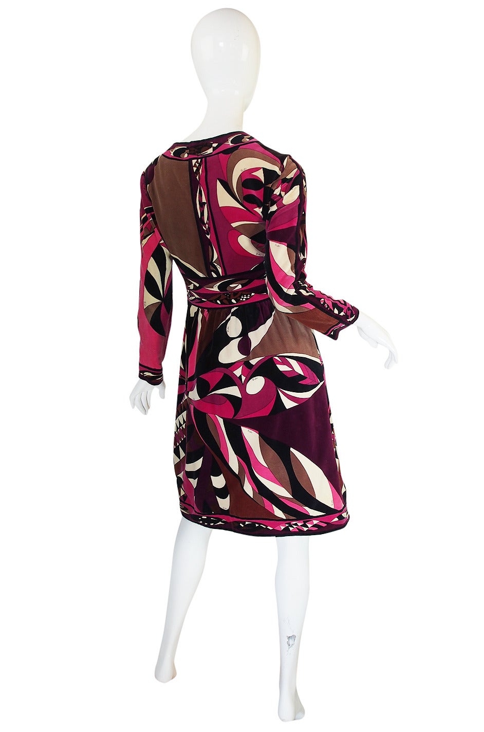 What a beautiful Pucci dress done in his signature, luxurious velvet and using a ruchly hued color palette of fuschias, deep burgundys and chocolates. The bodice skims over the bust with a V neck that scoops down to meet the angled band of