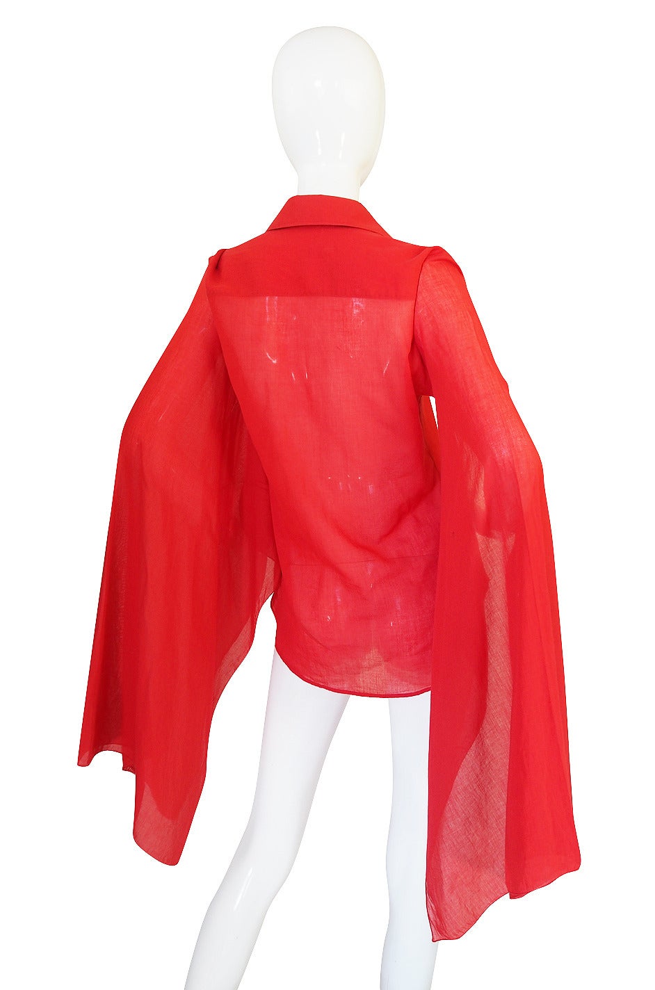 From the heady days of Tom Ford at Gucci comes this gorgeous little red, light weight, very fine cotton top with the most amazing sleeves. Through the torso it is cut like a typical button down with a pointed collar and Gucci engraved red buttons