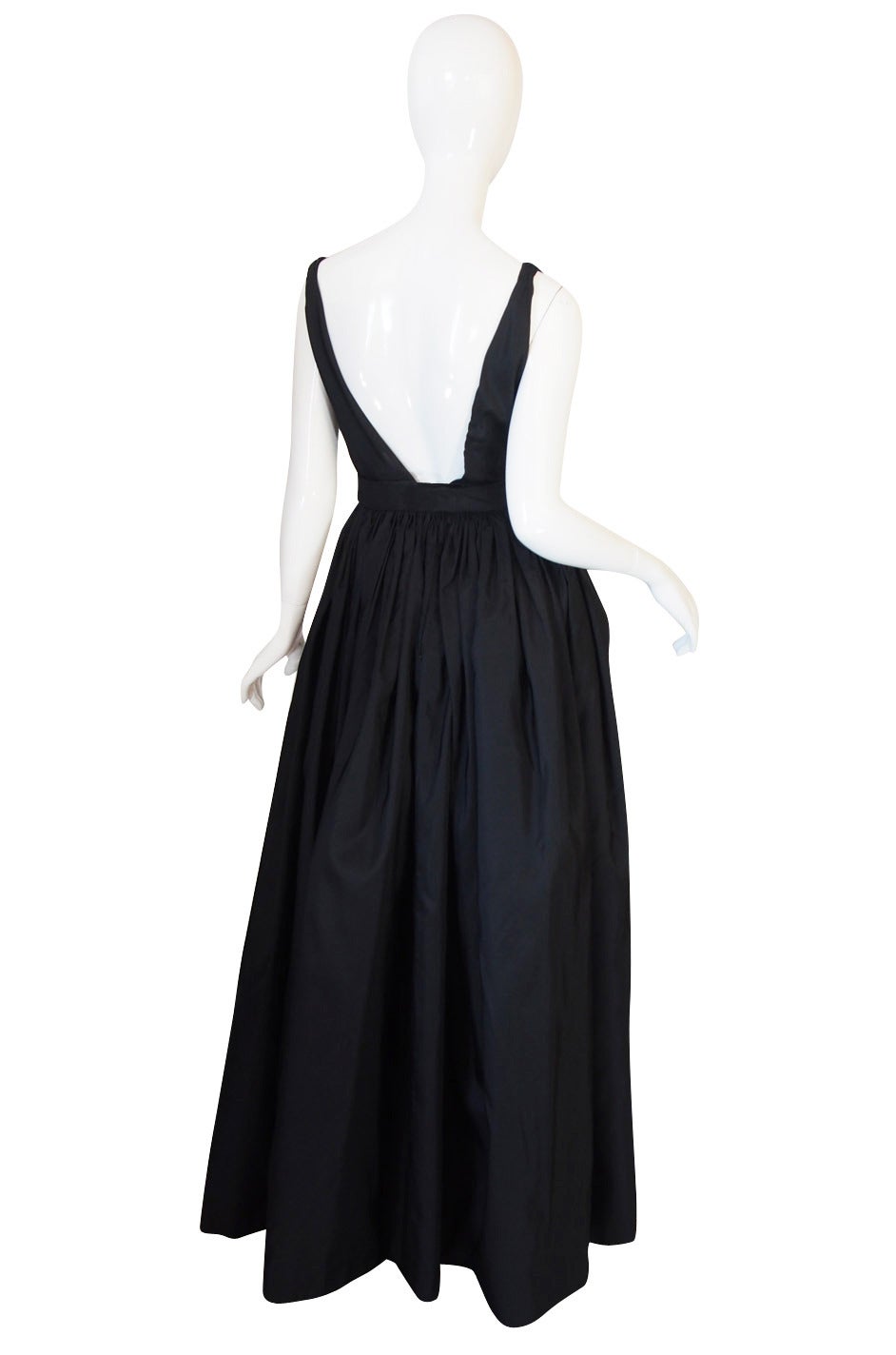 This phenomenal heavy black silk evening gown is undeniably exquisite in its cut and design. The sheer simplicity of line combined with that beautiful fabric combine to create one of the most beautiful gowns I have ever had pass through my hands.