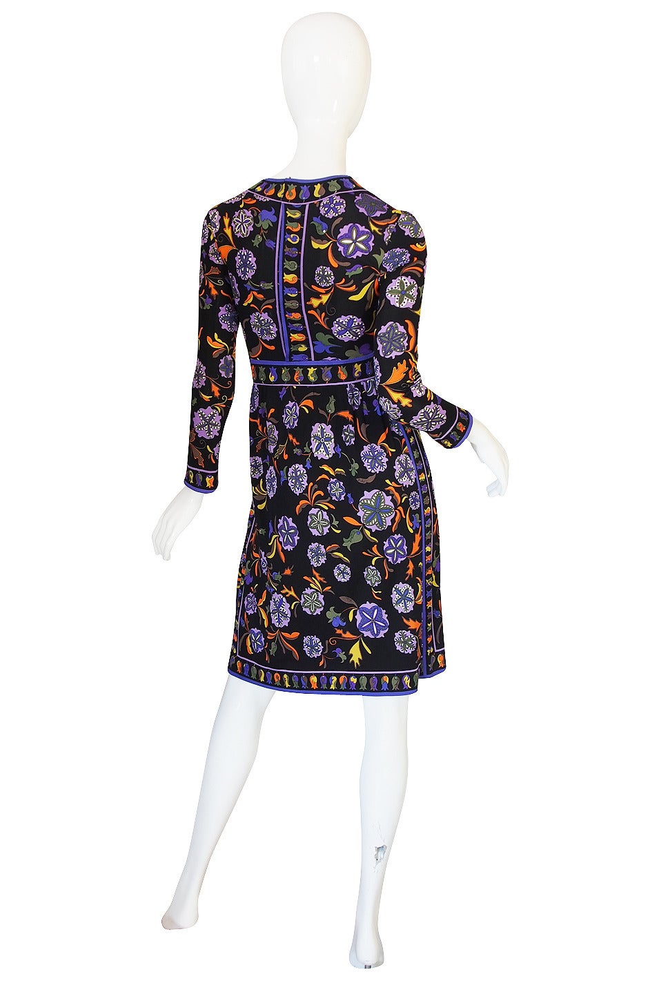 What a beautiful Pucci dress that is constructed from one of his signature silk jerseys with a bright pattern in a mix of colors that just pops off the black backdrop. The bodice skims over the bust to the waist and the waist is accented by a