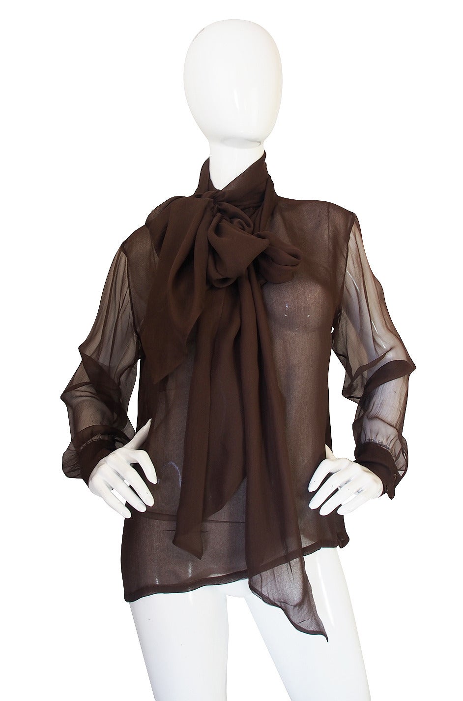 This Yves silk chiffon top is a beauty. The cut is loose and easy and the fabric a very fine silk chiffon that is a semi-transparent milk chocolate color. Each sleeve is cut to puff slightly above the two button cuffs. The attached tie at the neck