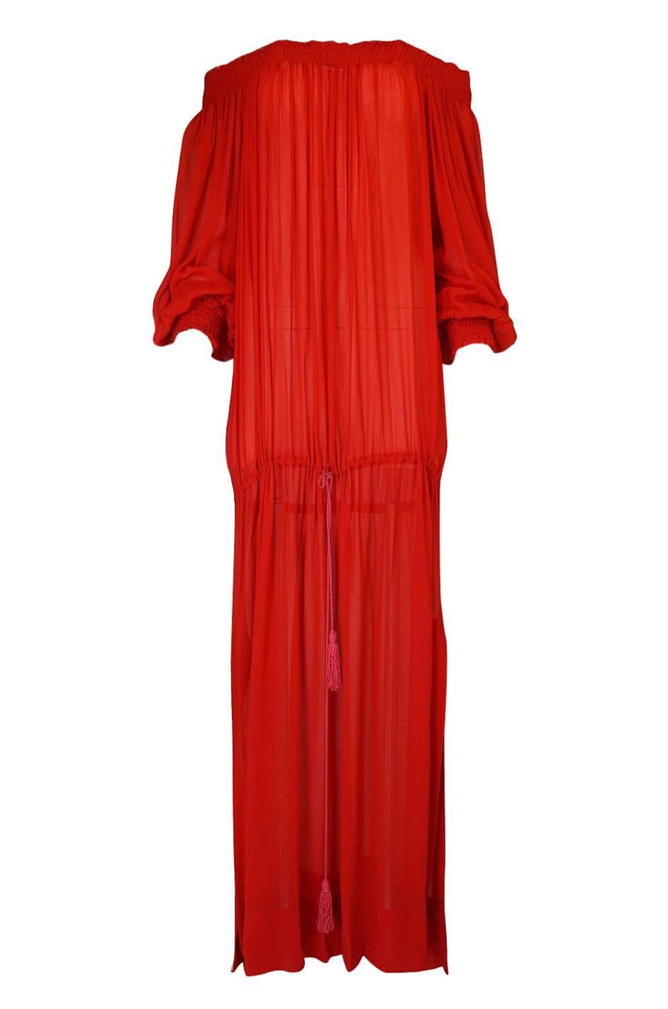 This red Yves Saint Laurent dress is especially fun because it can be worn so many different ways. Its like having a half dozen dresses in one. It is made from a red crepe silk gauze that has a touch of transparency to it. There are yards of fabric