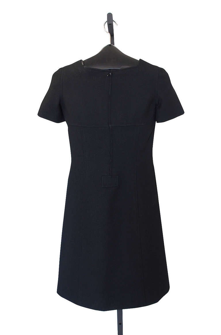 This is a stunning Courreges shift dress and one of his classic designs. The fabric is jet black and done in his signature fine wool with just a touch of texture running through it. Little cap sleeves and square neckline with button detail. The