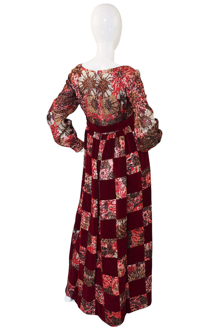 This Malcolm Starr is terrific - it is a unusual combination of a deep burgundy print gold metallic brocade mixed with a deep plush burgundy velvet. Cut with a nod to a baby doll silhouette the skirt is fairly full as it falls to the floor and the