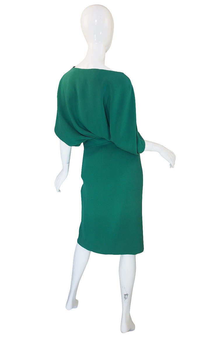 Beautiful and vibrant green Valentino has an unusual but fabulous cut. The top is almost cape like in its fullness and drapes beautifully over the pencil cut skirt. The opening fr the arm are cut along the seam and this in itself creates an