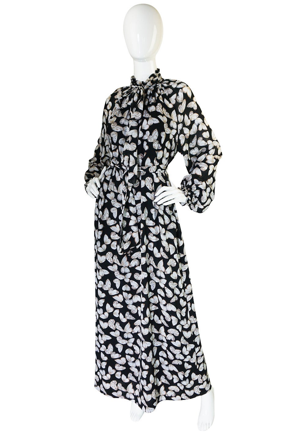 I love this fabulous late 1970s Hanae Mori caftan dress with its butterfly design covering the entire surface. It is made of a feather light silk crepe that really hold the colors beautifully. The gown is cut super model long and is constructed of