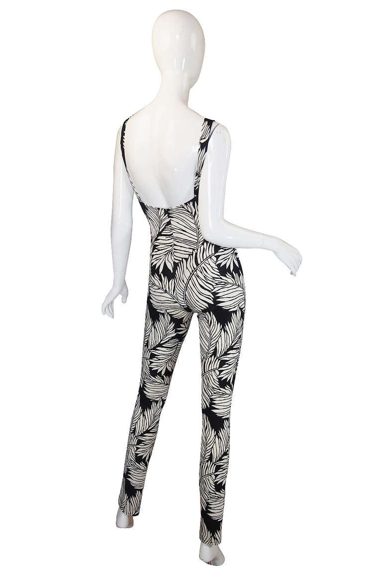 Spectacular eighties one piece jumpsuit from Norma Kamali that is super sexy! The one piece fitted pull on is made of a stretch jersey that has a bold black and white palm print. It is cut crazy high waisted so its sits just under the bust and then