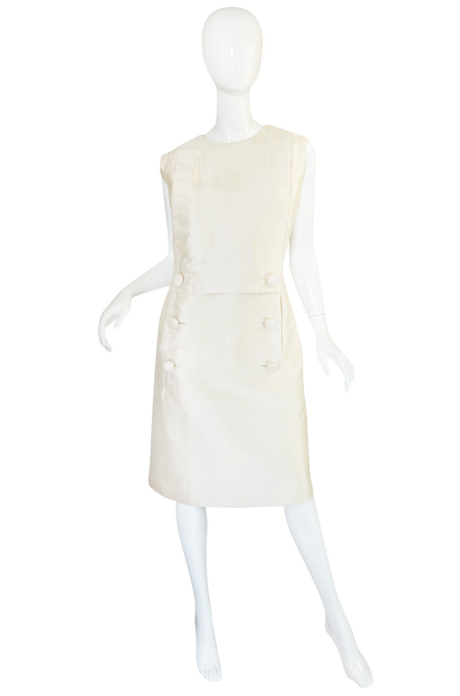 This dress and coat set in a rich cream silk is extraordinary. After much research I believe it to be based on the Spring 1960, Yves Saint Laurent for Christian Dior collection. You can see a striking similarity to the cut, collar and buttons of the
