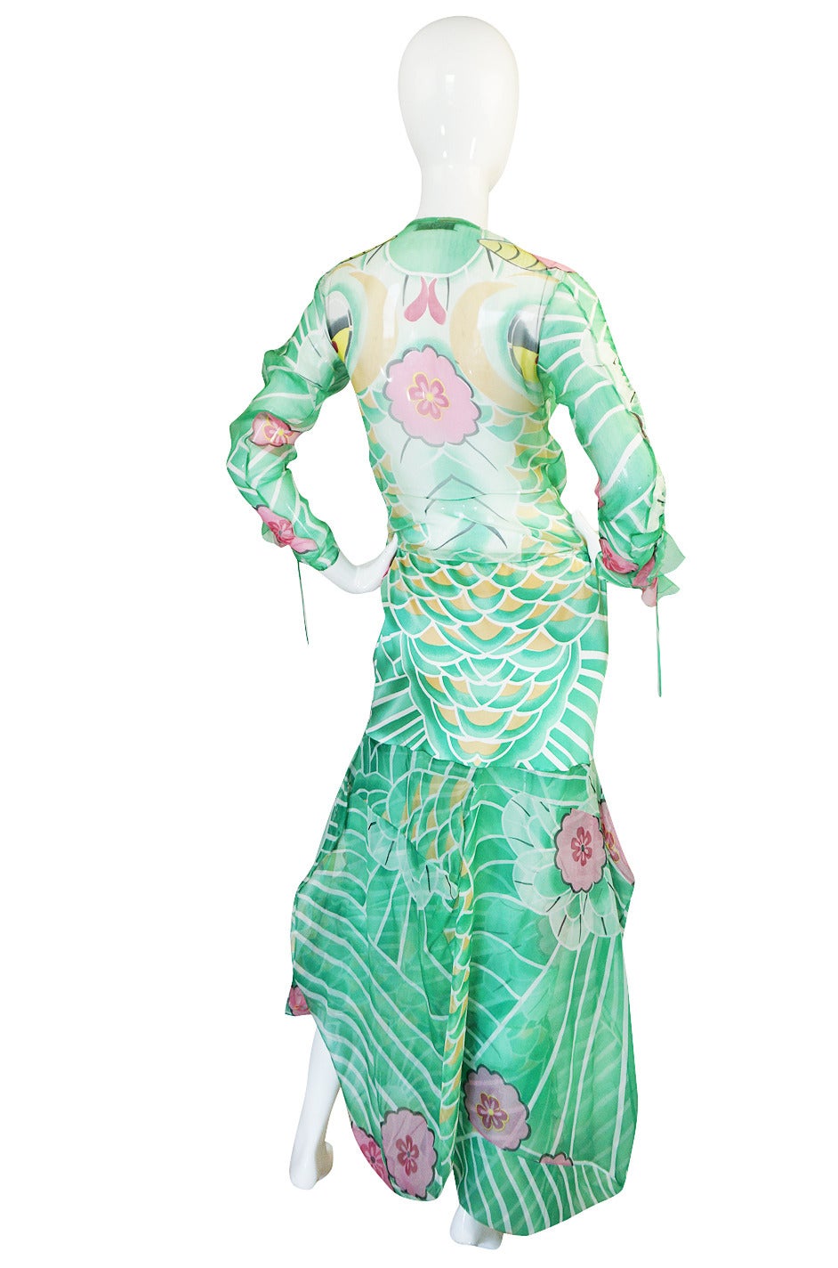 The set from the fall 2003 collection is gorgeous. This print was done in both look 21 and 22 and I from the photos I believe it to be look 22. It is done in a bright print of green with vivid pops of color. There is and nod to the East in the
