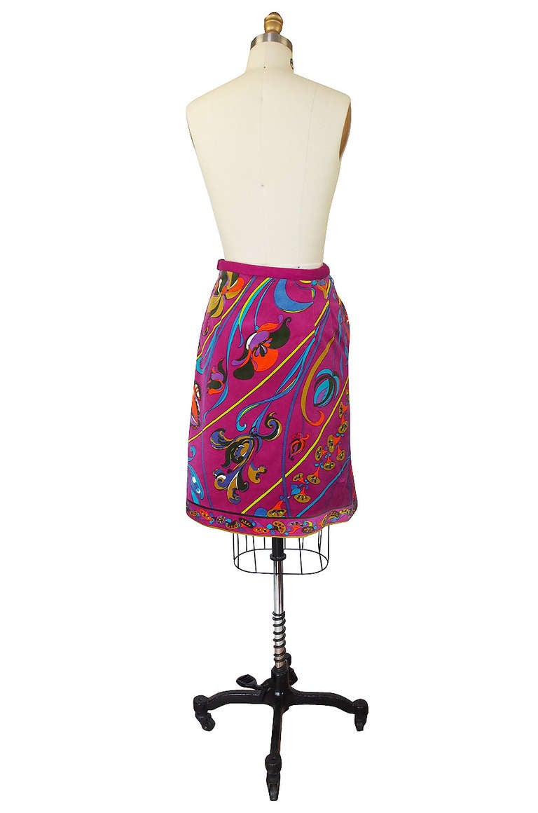 Gorgeous cotton velvet skirt by the Emilio Pucci has been done in a beautiful mix of vibrant colors. A deep pink base has a trailing floral design that runs across the surface within an angled line pattern. The edge of the hem is printed with a
