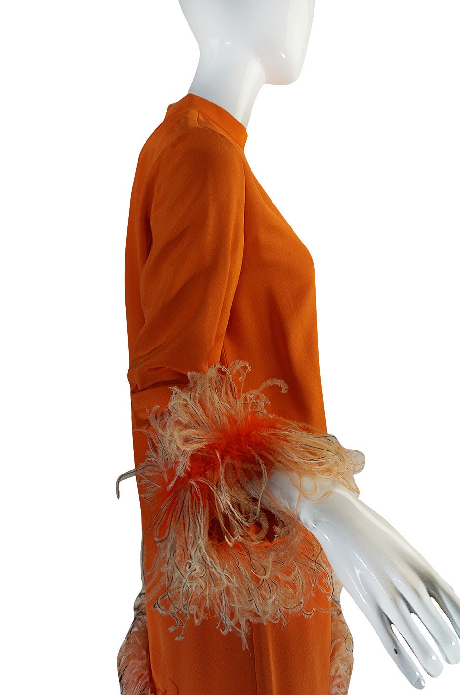 This absolutely stunning, silk & feather dress is by Geoffey Beene, who one of my favorite American designers. This is made to demi-couture standards and it shows. It is a fantastical combination of a bright orange-coral silk with amazing feather