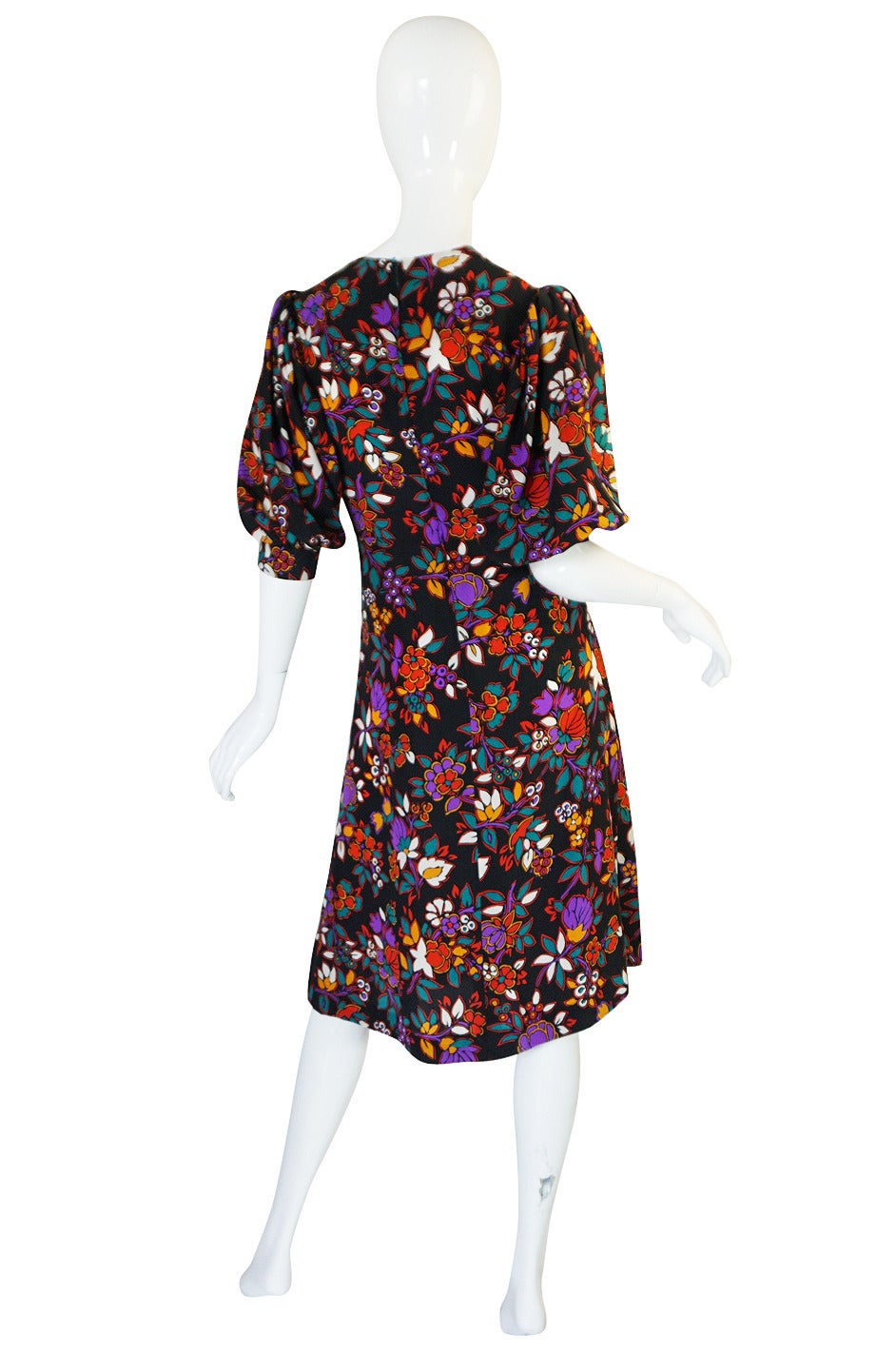 Florals and Yves Saint Laurent were always the perfect combination and in this darling little silk fine light silk dress that is shown to its best! Over a black back drop are a riot of multi-colored, bright and bold flowers strewn over its surface.
