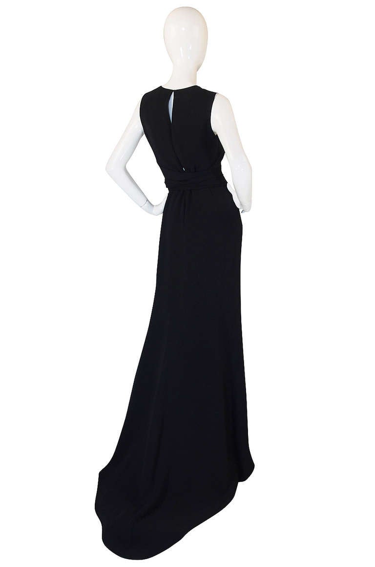 An amazing fine wool stretch jersey gown by Oscar De la Renta that skims over the body and is not meant to be skin tight, yet manages to emphasize every curve. It is long and lean in all the right ways. It is constructed in a long flowing drape of