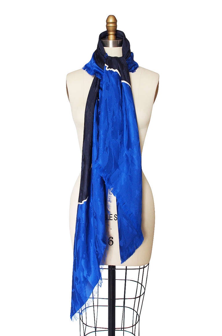 Gorgeous and huge, this silk Yves Saint Laurent scarf is a mix of  his signature bold blue bordering a deeper blue separated with a pop of white. Soft fringed edges and it is super light weight. The sheer size of it will allow you to wear and style