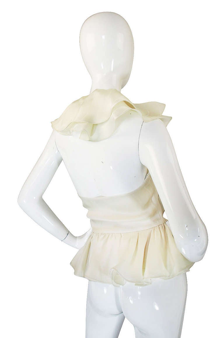 This stunning Bill Blass halter top is a glorious confection of ruffles done in a beautiful pale cafe au lait silk. Additionally he has chose a silk that has a fine stripe worked through it so you get this subtle secondary texture feel which is