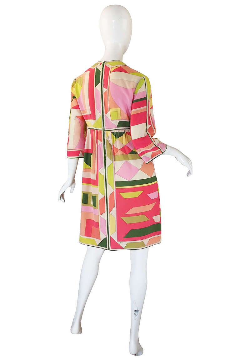 What a beautiful Pucci dress done in one of his signature bright, citrus mixes colors and using one of his iconic angled prints screened onto a scarf weight silk. The bodice skims over the bust to the border trimmed, high waist line. Another border