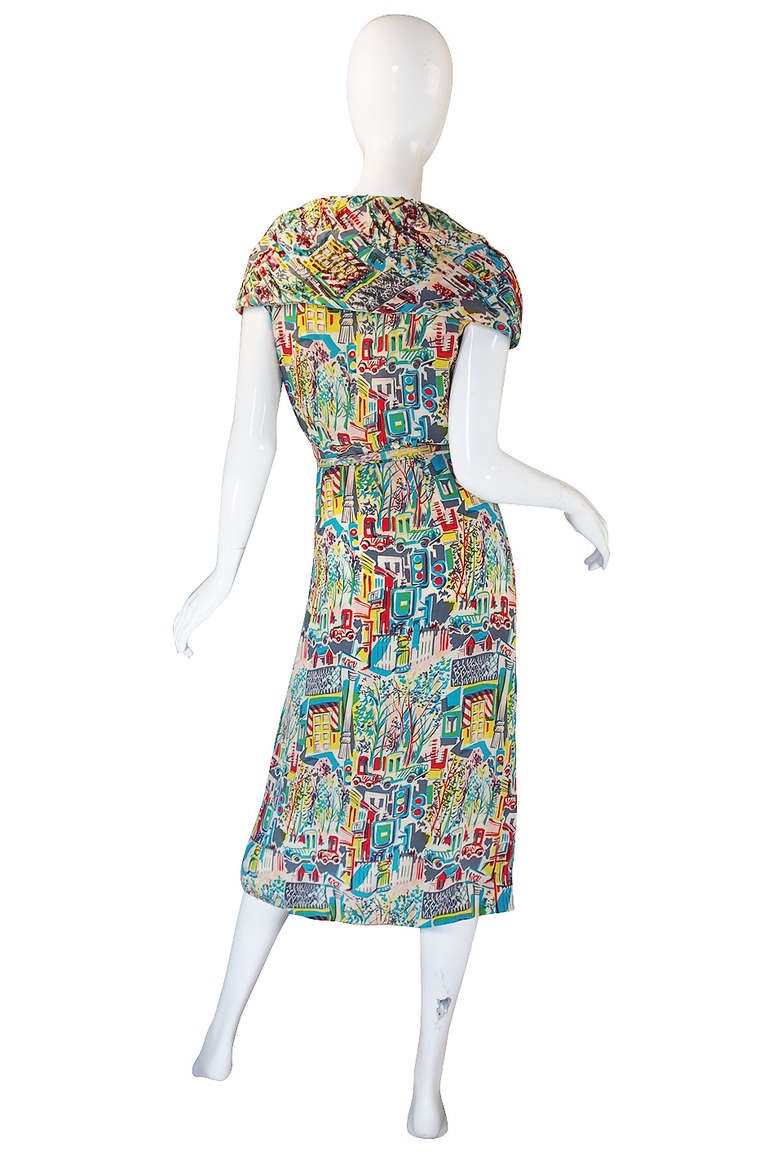 What a glorious 1940s swing dress! These are getting harder and harder to find and to find a jewel like this one is just wonderful and on top of that it is by the talented Jo Copeland for Pattulo! The fabric is a printed silk crepe that drapes