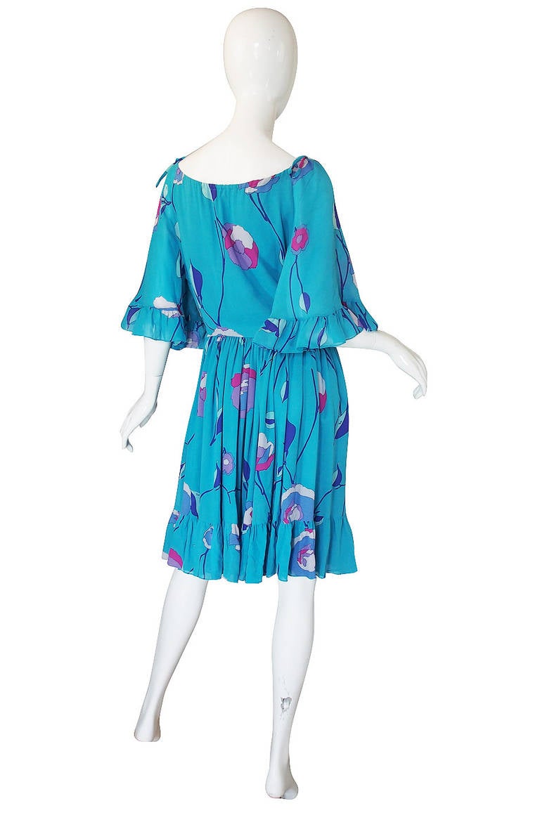 The color of this dress is wonderful! It is a beautiful turquoise and the pops of pink and purple against it really world perfectly! The cut on this is very girlie and not your typical Pucci but I love it. The sleeves are very wide and full and each